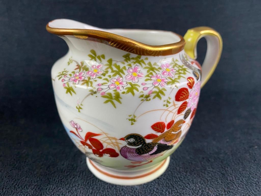 Vintage Japanese Porcelain Creamer: Vintage Japanese Porcelain Creamer Vintage hand-painted porcelain creamer from Japan. Features birds and flowers around the sides. In good condition with no known cracks, and only a couple of small