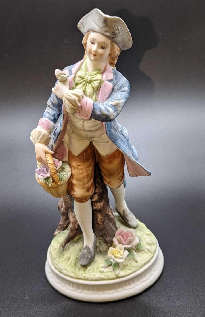 Lefton China Colonial Dressed Man With Flowers Figurine: Lefton China Colonial Dressed Man With Flowers Figurine. This is approx 3 1/2" x 3 1/2" x 7 1/2" and it weighs 0.82lb. The back left of the coat's bottom has a crack.