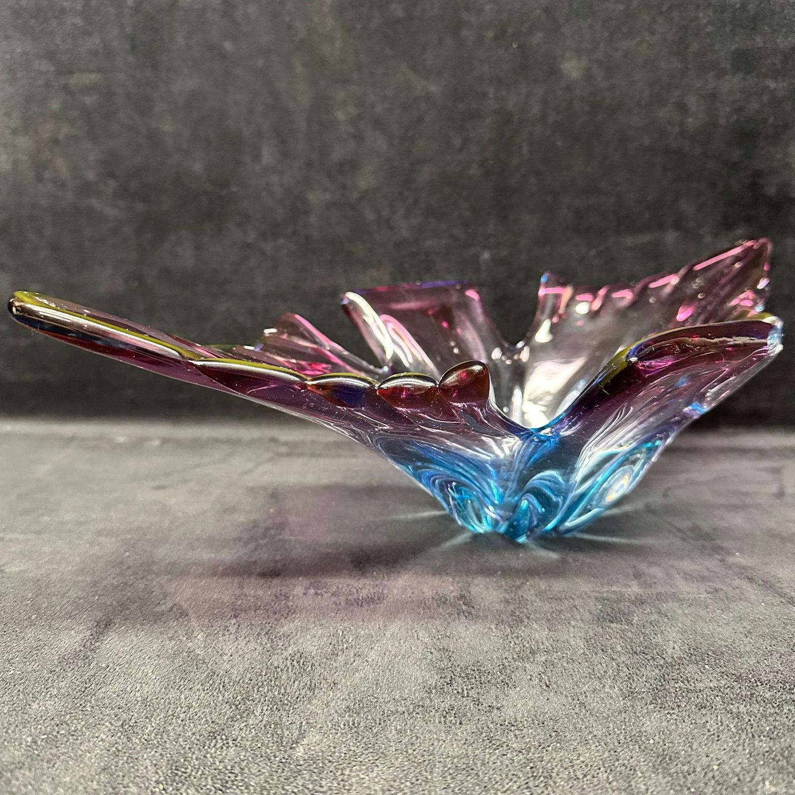 Murano Style Art Glass Fan Bowl Unmarked Pink and Blue: Vibrant hand-blown art glass centerpiece bowl in a dramatic fan/leaf form with deeply pulled ribs and pinched, wing-like sides. Color fades from aqua blue at the well to amethyst/rose pink. Ground, st