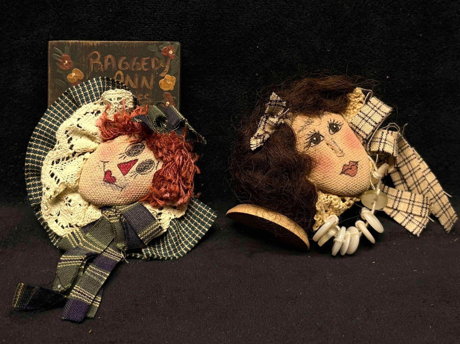 2pc Handmade Folk Art Doll Pins featuring Raggedy Ann: This lot contains two (2) pre-owned, handmade Americana folk art doll brooches. Their age is visible through the discoloration found on the surface fabric of each brooch, however, still maintains its 