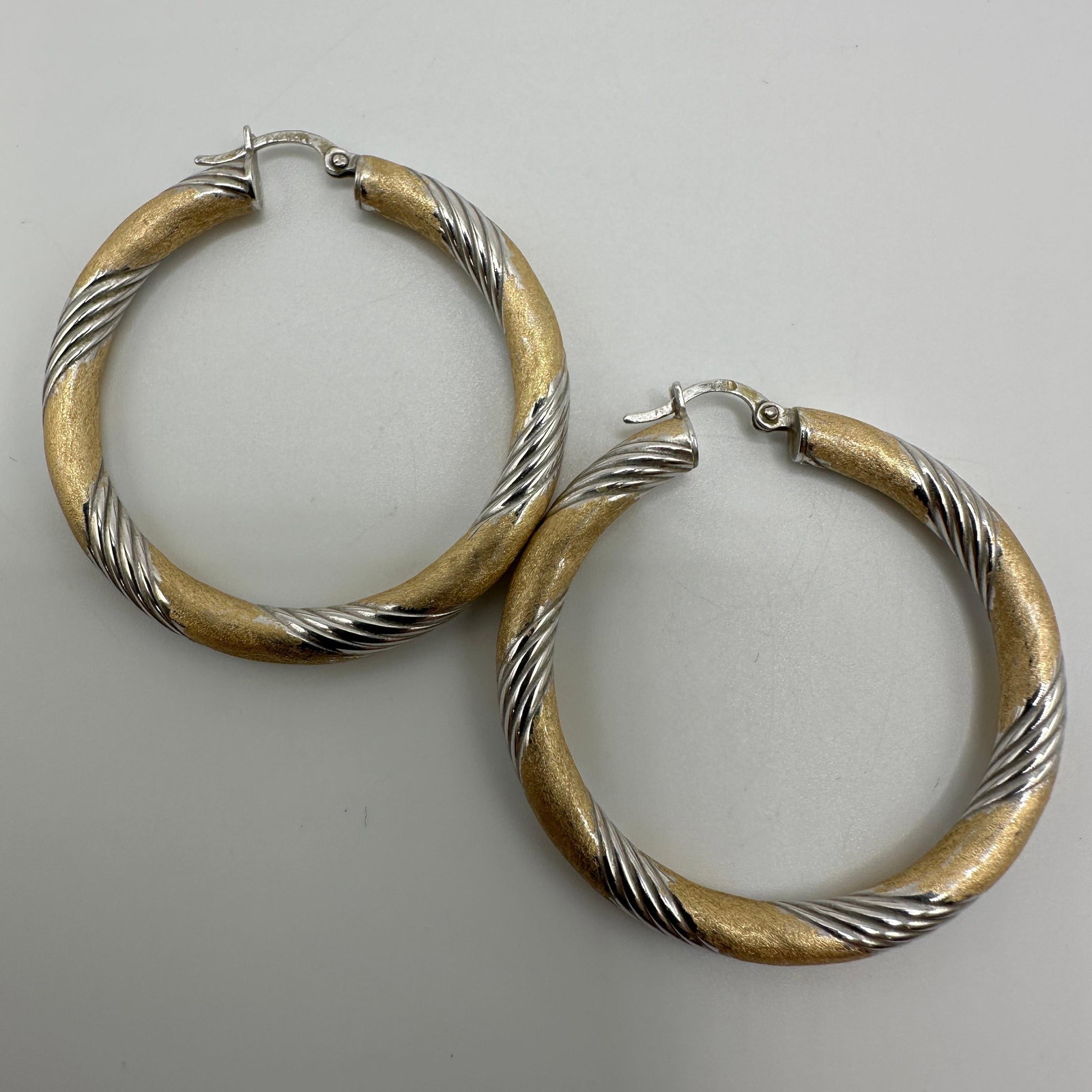 Italy 14K White Yellow Gold Twist Textured Hoop Earrings: This item is in good pre-owned condition, previously used/displayed, with noticeable light wear and surface scratches. Please reference all photos for full details. This piece of jewelry has been