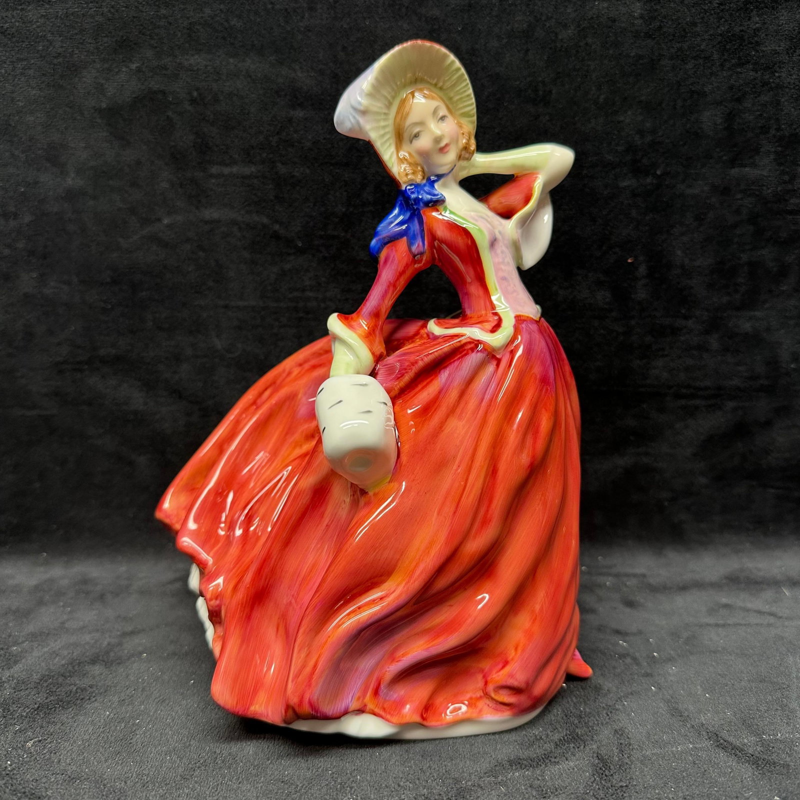 Royal Doulton Autumn Breezes HN1934 Porcelain Lady Figurine: Royal Doulton porcelain lady figurine titled Autumn Breezes HN1934. Marked on the underside Royal Doulton England with model number. No chips or cracks observed, light surface wear present. This 