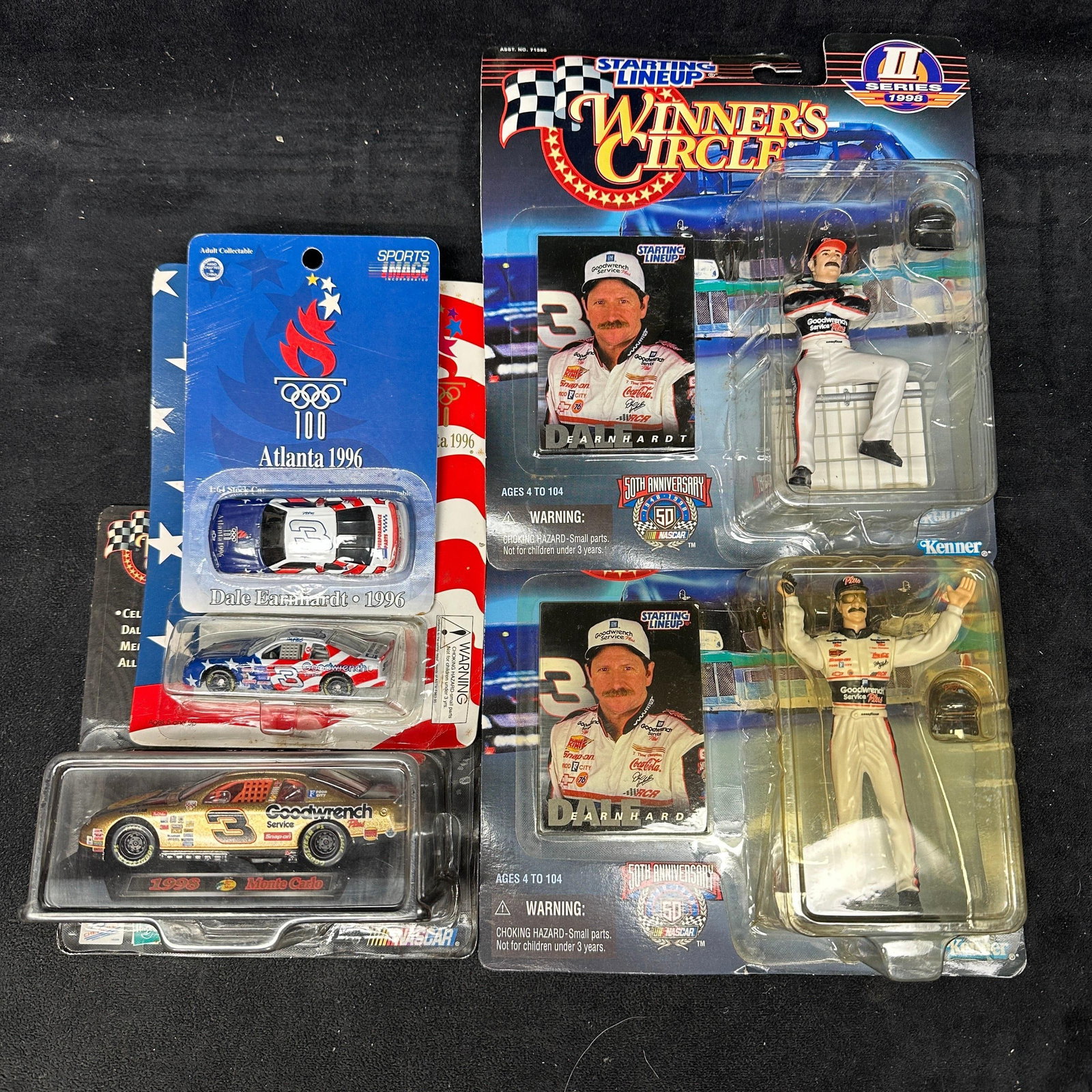 Dale Earnhardt NASCAR Winners Circle And Die Cast Collectibles Group: Group of Dale Earnhardt NASCAR collectibles, including two 1998 Starting Lineup Winner’s Circle action figures by Kenner, 1996 Atlanta Olympics Sports Image 1:64 stock car, Revell Goodwrench die