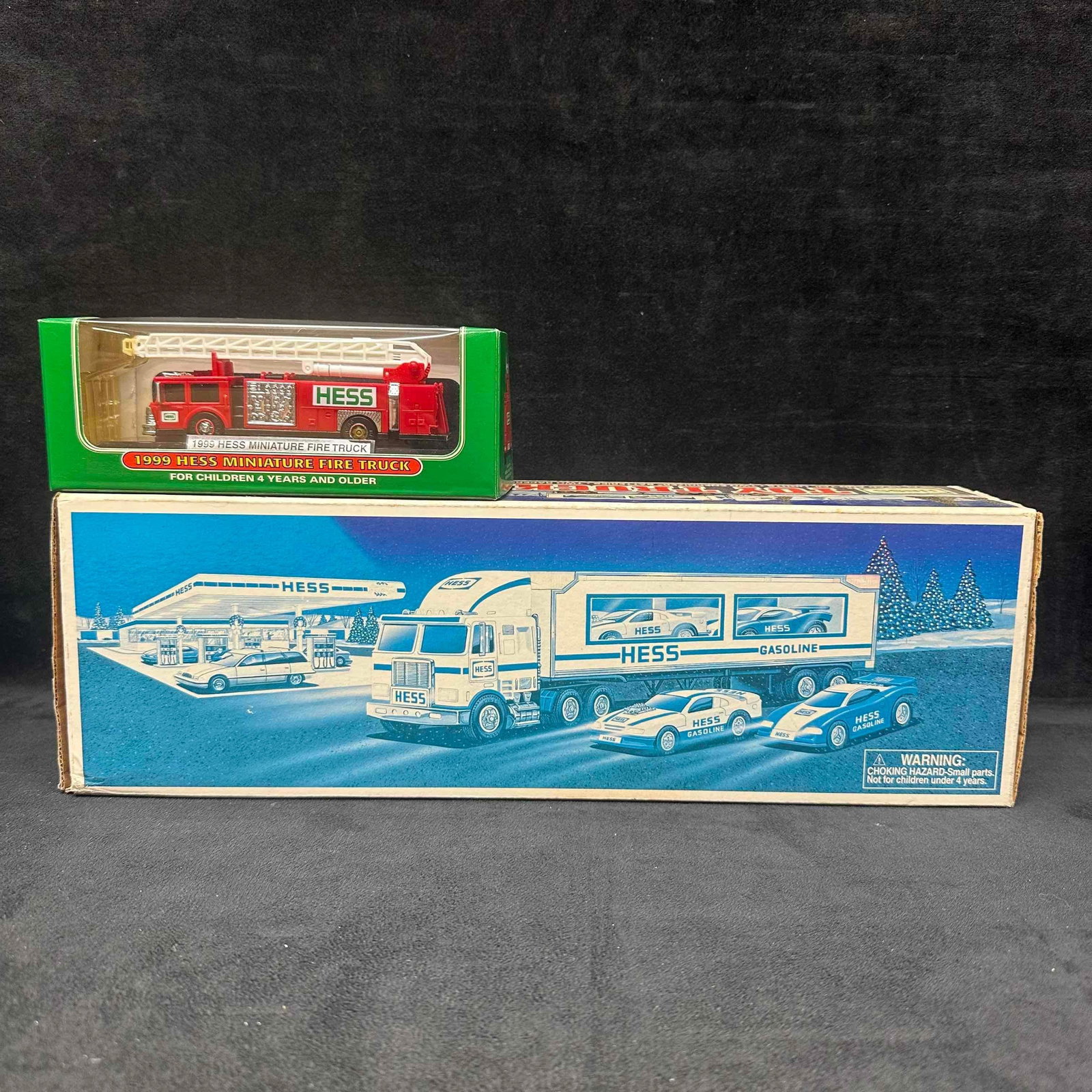 1988 Hess Toy Truck and Race Cars and 1999 Hess Miniature Fire Truck Set: Original 1988 Hess Toy Truck and Race Cars complete with it's box, featuring a gasoline truck and two race cars. Also included is the 1999 Hess Miniature Fire Truck, still sealed in its display bo