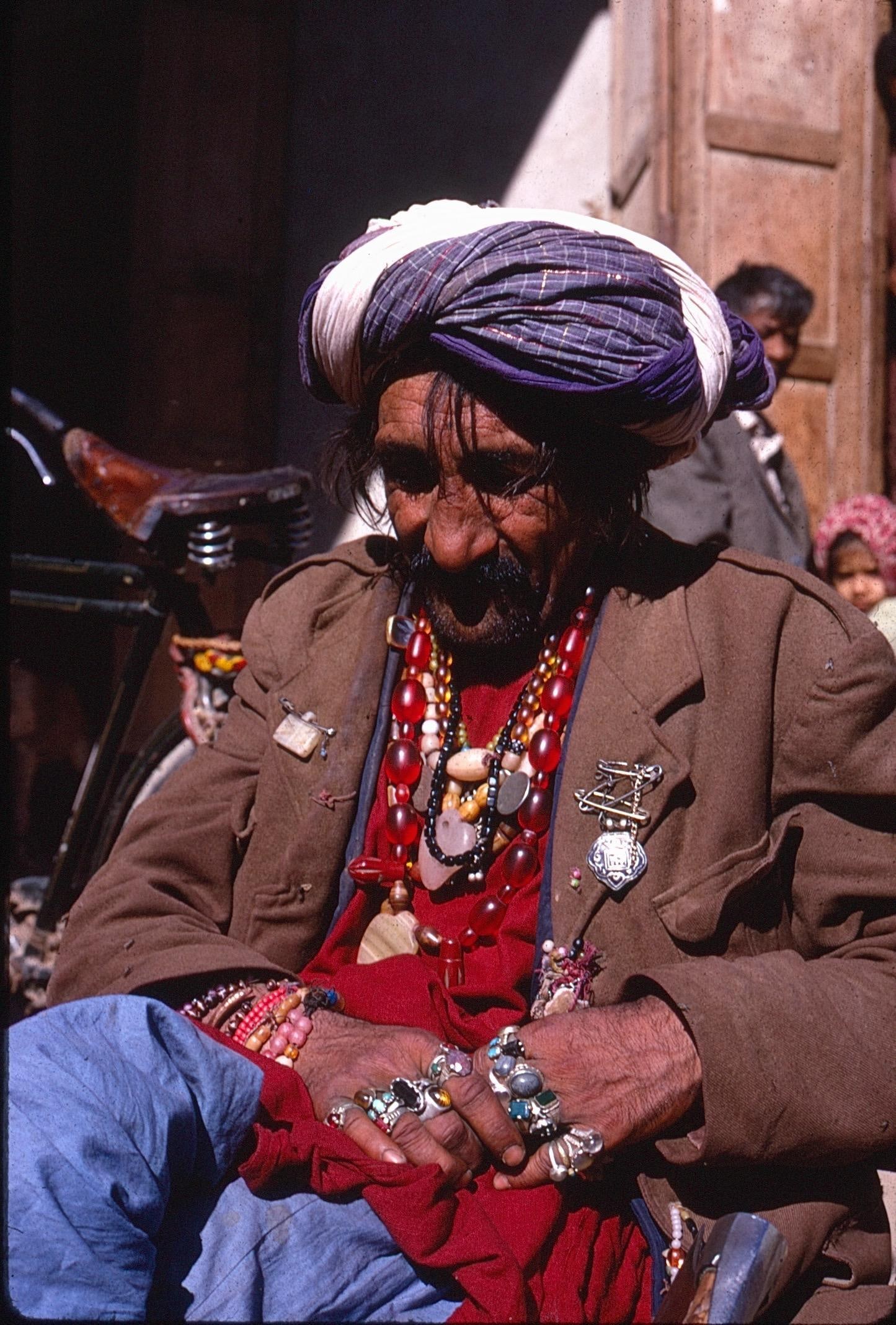 Portrait of a Bejeweled Elder with Turban Kodachrome Slide with 2 Color Digital Prints: Kodachrome slide with two digital color prints depicting a striking portrait of an elderly man adorned with multiple rings, necklaces, beads, and pins, wearing a turban and jacket. The image captures 
