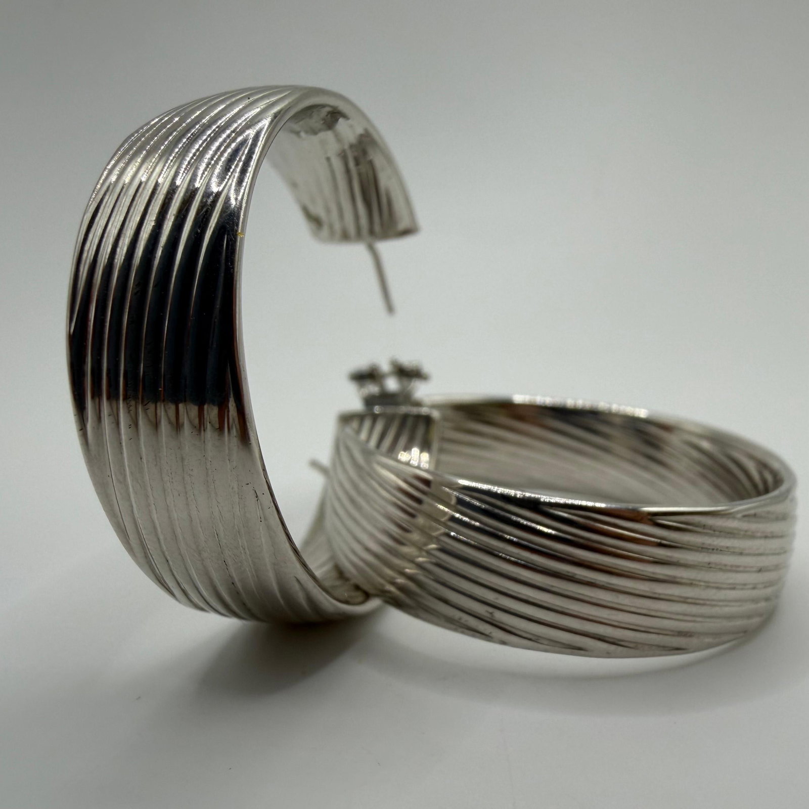 Bronze Milor Polished Silver Tone Hoop Ribbed Earrings: High-quality ribbed statement earrings by Italian brand Milor, marked Bronze, featuring a polished silver tone design. These items are pre-owned, with light wear and surface scratches. Please referenc