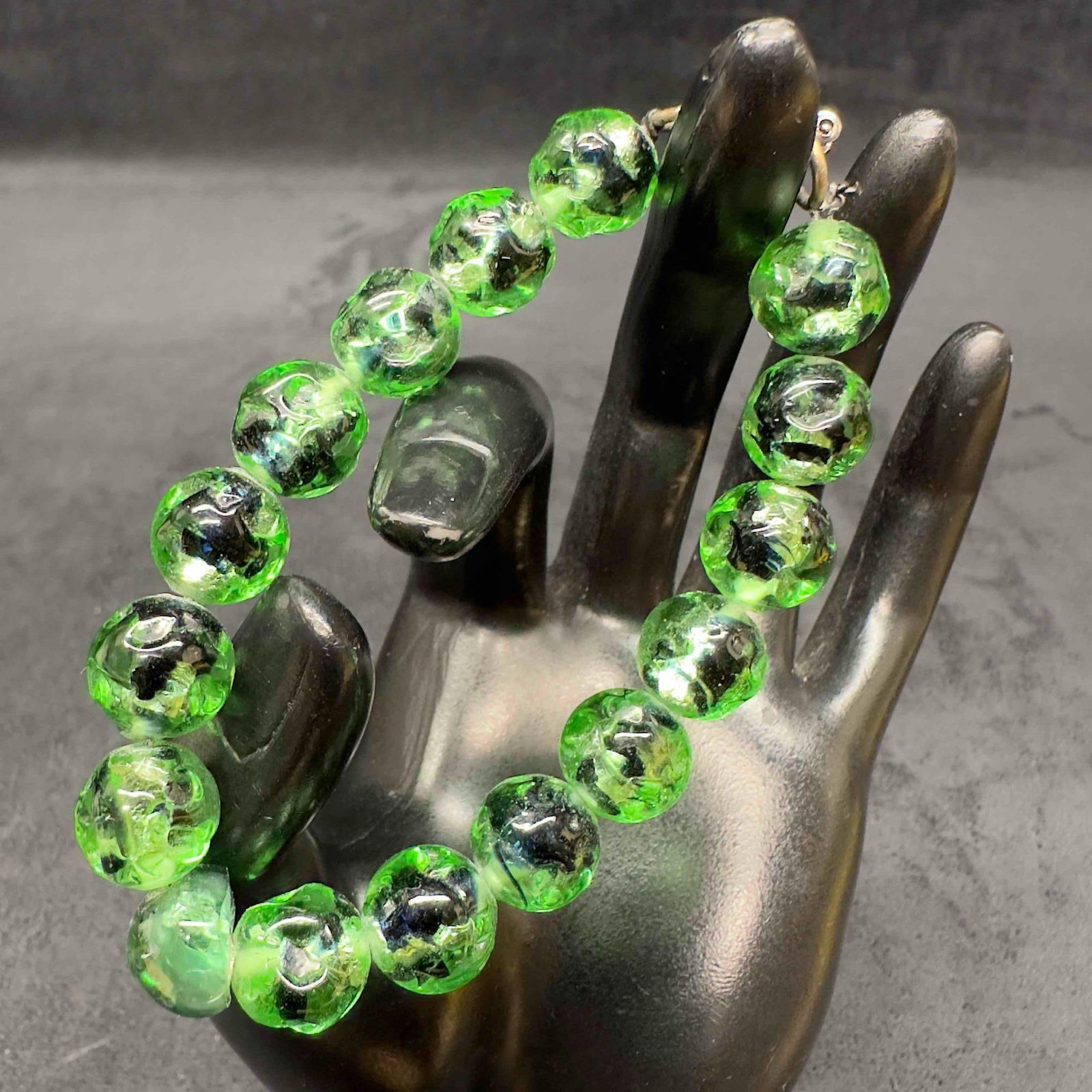 Venetian Murano Lamp Work Art Glass Round Clear Green Bead Bracelet E67: Venetian Murano Lamp Work Art Glass Round Clear Green Bead Bracelet E67. Bracelet with clear green colored glass beads with beautiful designs on each. The bracelet features black colored accents. The 