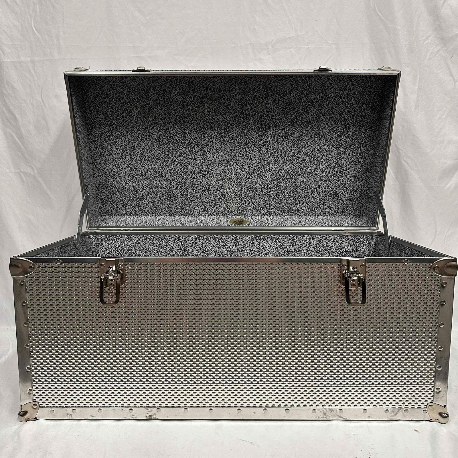 Seward Trunk Embossed Steel Nickel Storage Chest Footlocker: Design with a strong textured steel covering, reinforced metal corners and riveted detail. Leather haul handles on either side. Paper lined interior. Shows distressing and wear/blemishes/dings/scratch
