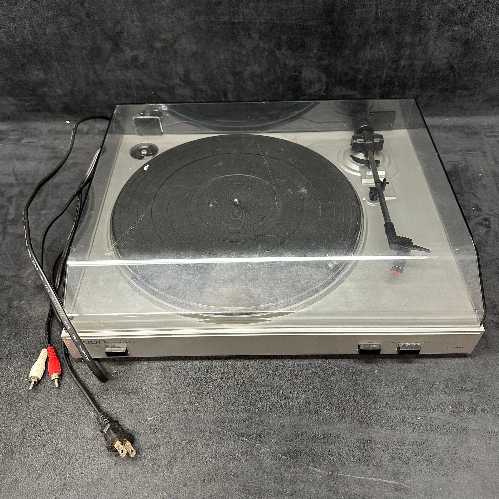ION USB Turntable Model iTTUSB05 Tested One Hinge Repaired: ION USB Turntable, model iTTUSB05, designed for playing 33 and 45 RPM records with the option to convert vinyl to digital via USB. Comes with attached RCA and power cords. Dust cover shows scratches