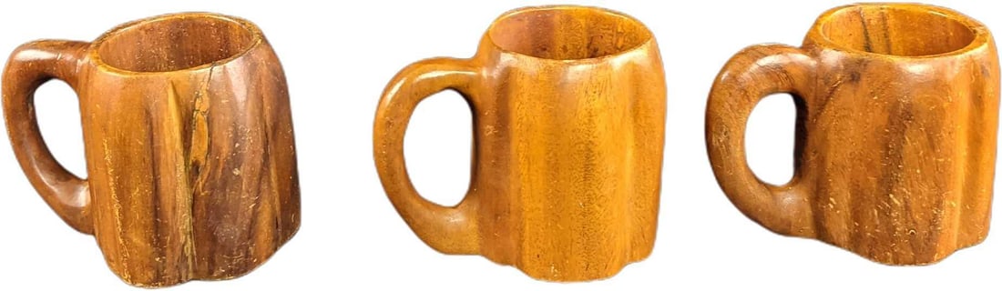 Three Vintage Hand Carved Monkey Pod Steins Mugs: Three Vintage Hand Carved Monkey Pod Steins/Mugs. First mug is approx 6 1/2" x 4" x 5". The second mug is approx 6 1/2" x 4 1/2" x 5". The third is approx 6 1/2" x 4 1/2" x 4 3/4". Together they