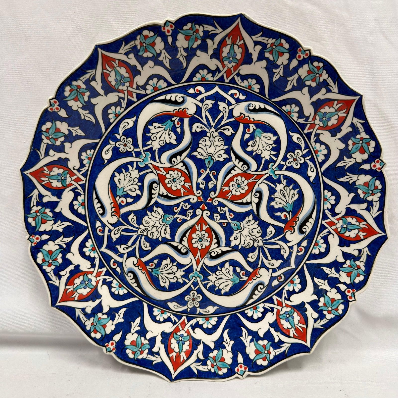 Turkish Altin Cini Hand-Painted Traditional Kutahya Folk Art Iznik Style Ceramic Charger Plate: Hand-painted ceramic charger plate by Altin Cini, Kutahya, Turkey. Decorated in traditional Iznik style with blue, red, turquoise, and white floral and bird motifs. Marked "Altin Cini Hand Made Ku