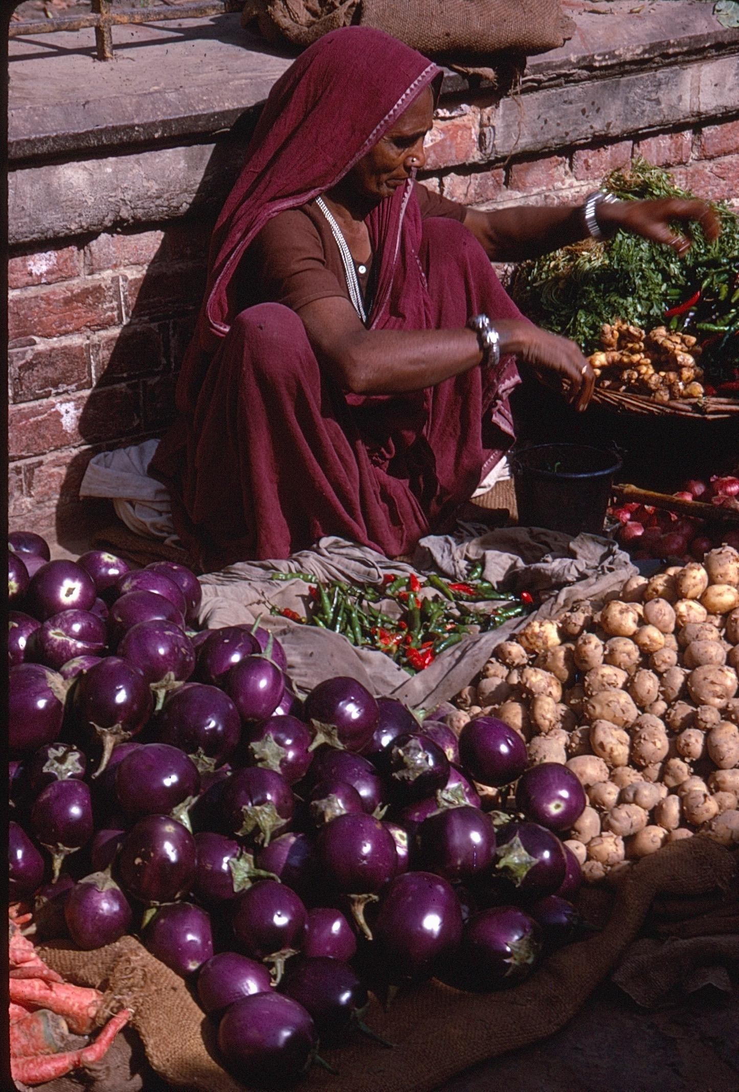 Vintage Kodachrome Photo Slide with Digital Prints Indian Market Vegetable Vendor: Original Kodachrome color slide with accompanying digital prints depicting a striking street market scene. The image features a woman vendor in traditional attire seated beside baskets and displays of