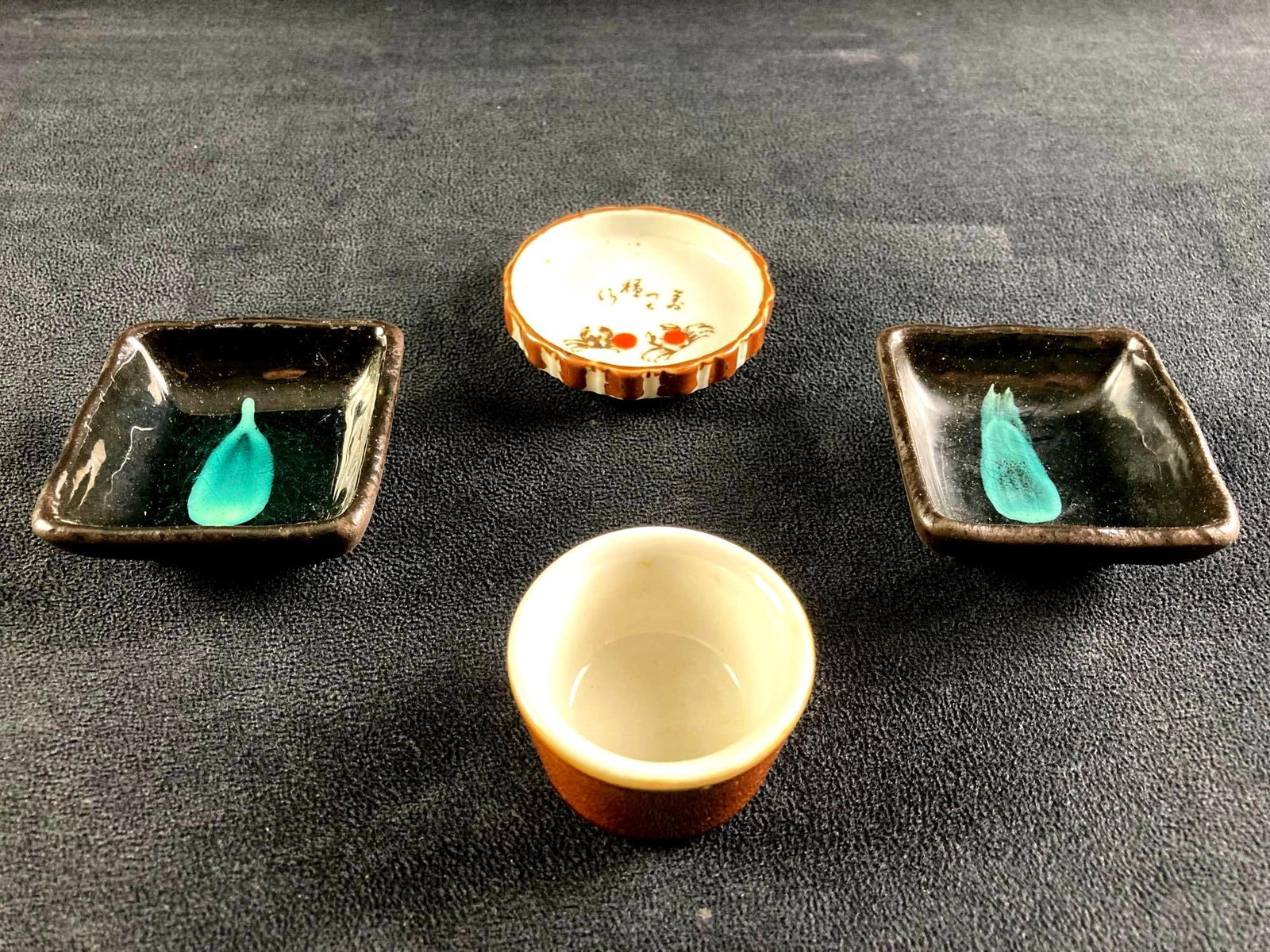 (1) Small Japanese Set of Dining China: This lot includes: (2) Small Japanese Soy Sauce Trays (1) Sake Cup (1) Crab Decorated Soy Sauce Cup Condition is used and see photographs for additional details. The trays are decorated with a small