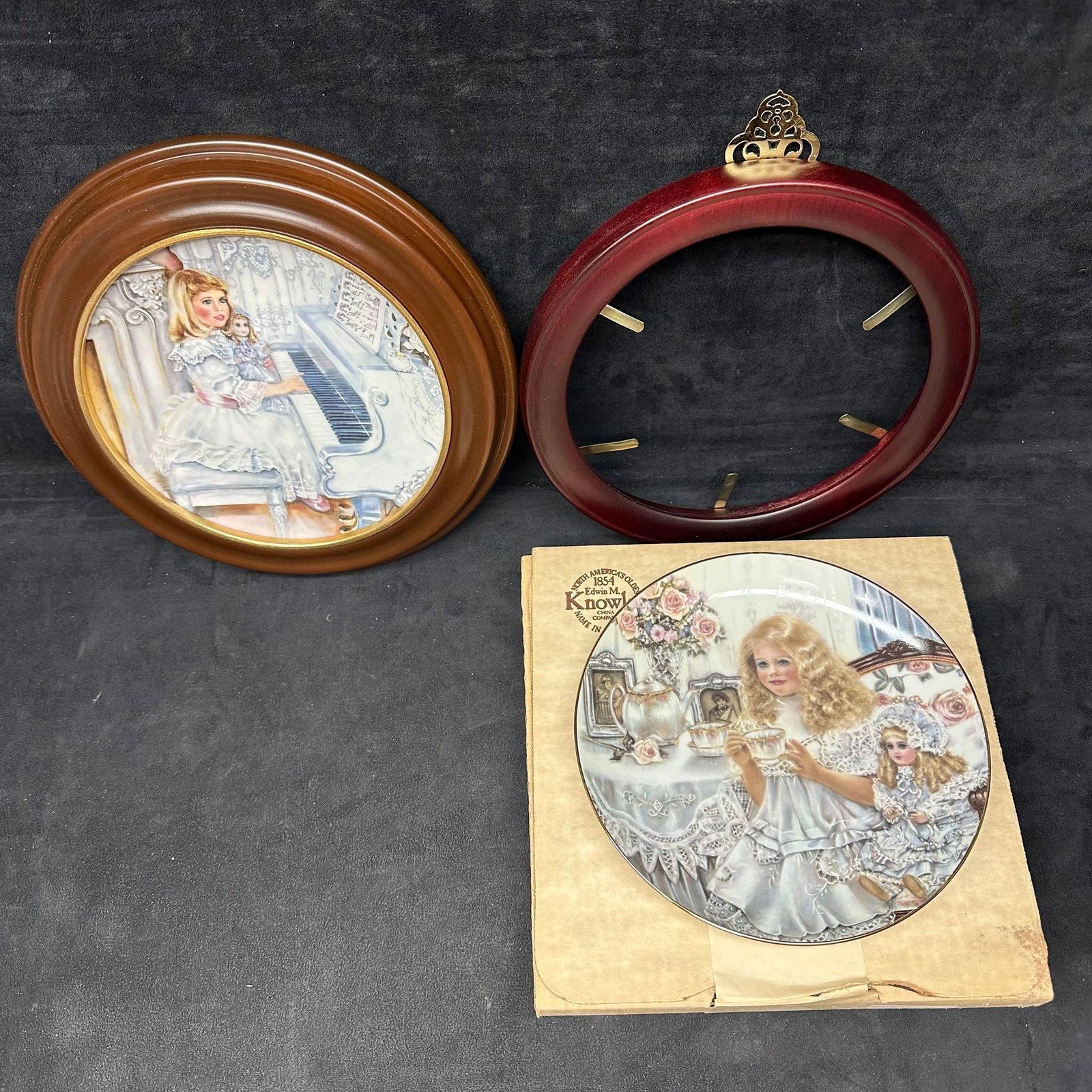 Signed Corinne Layton Collector Plates and Wood Frame Holders Lot Edwin M. Knowles Plate: A lot of Corinne Layton collector pieces, including two Edwin M. Knowles limited-edition plates and two wooden frame holder displays. Includes: Victorian plate with original box and paperwork (signed 