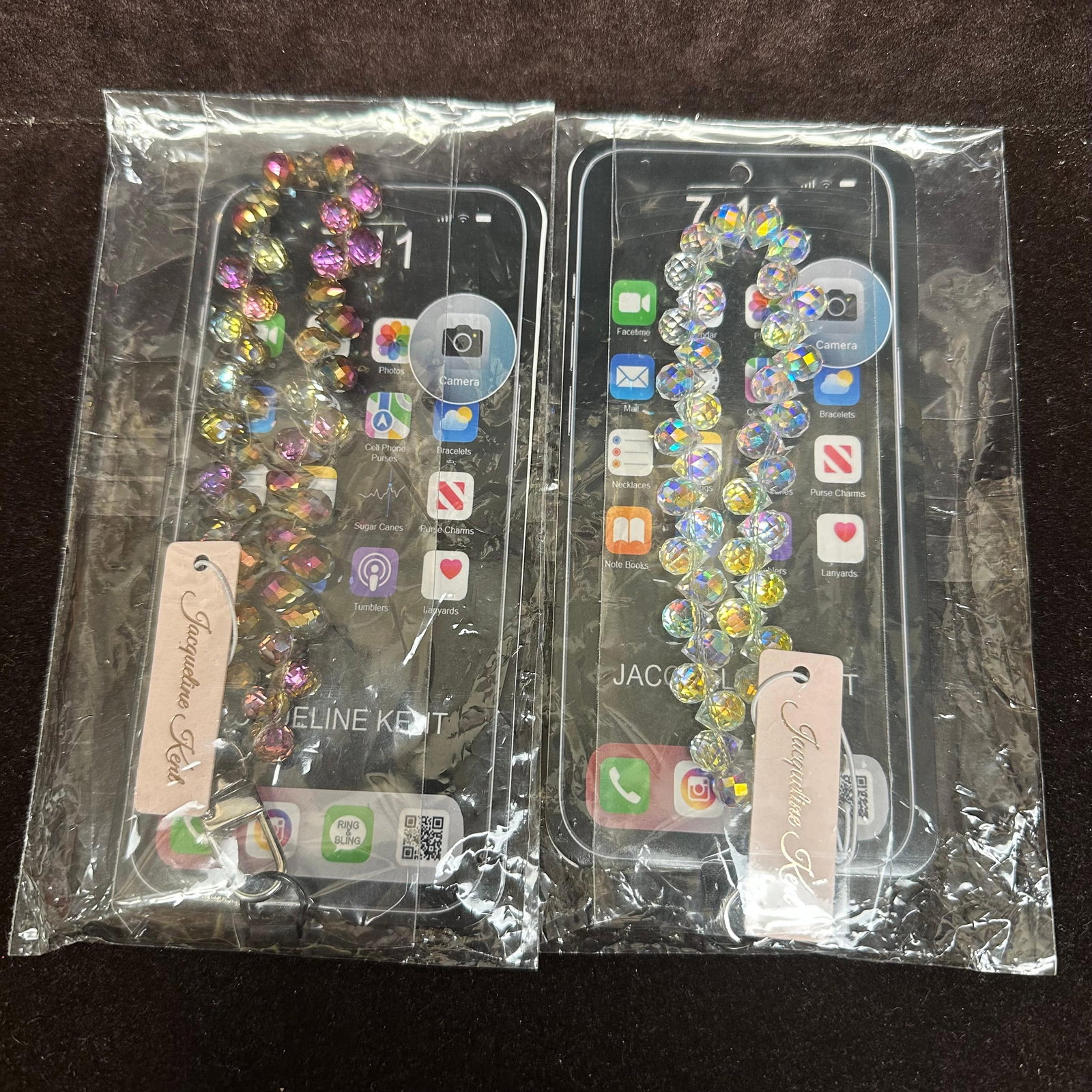 Jacqueline Kent Crystal Embellished Phone Wrist Strap Pair of Two: Jacqueline Kent Crystal Embellished Phone Wrist Strap, both are still sealed. Purple and white/clear colored crystal embellishments. These items are in like-new, previously displayed condition with li