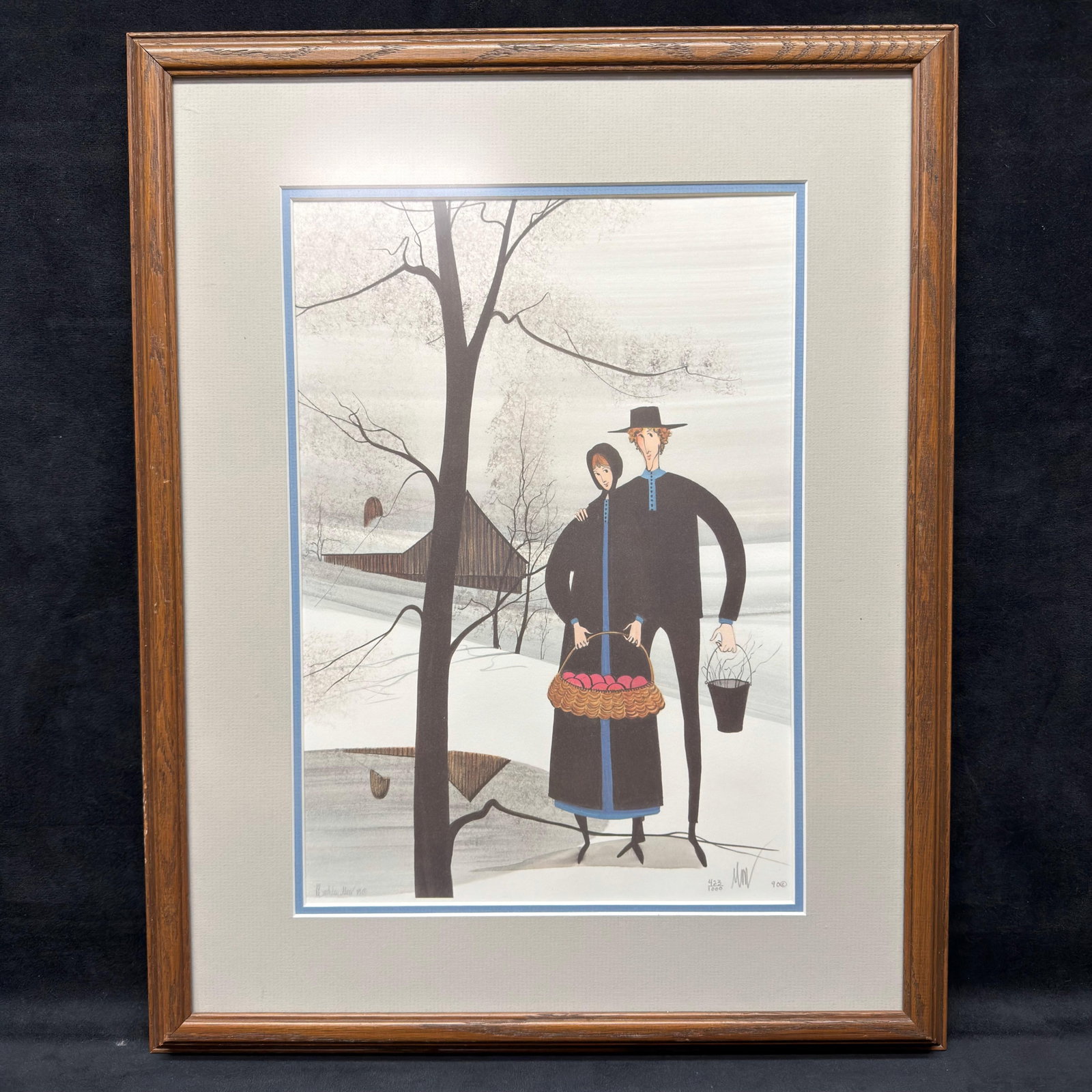 Patricia Buckley Moss Days Work Over Signed and Numbered Framed Print: Limited edition print by acclaimed American folk artist Patricia Buckley Moss depicting an Amish couple in a serene winter landscape with a basket of red apples, a sap bucket, and a traditional Pennsy