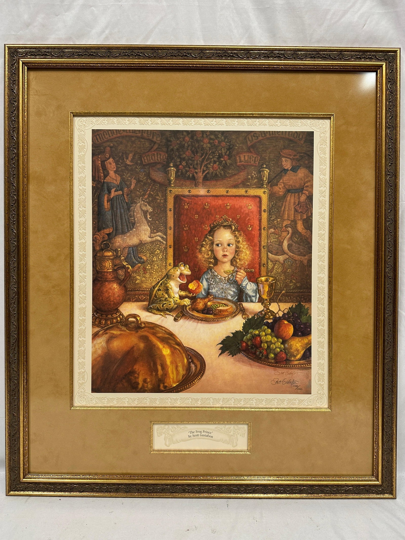 Scott Gustafson The Frog Prince Signed and Numbered Framed Print: Framed limited edition print titled The Frog Prince by acclaimed American illustrator Scott Gustafson. The artwork depicts a classic fairy-tale scene, with the princess seated at a royal banquet besid