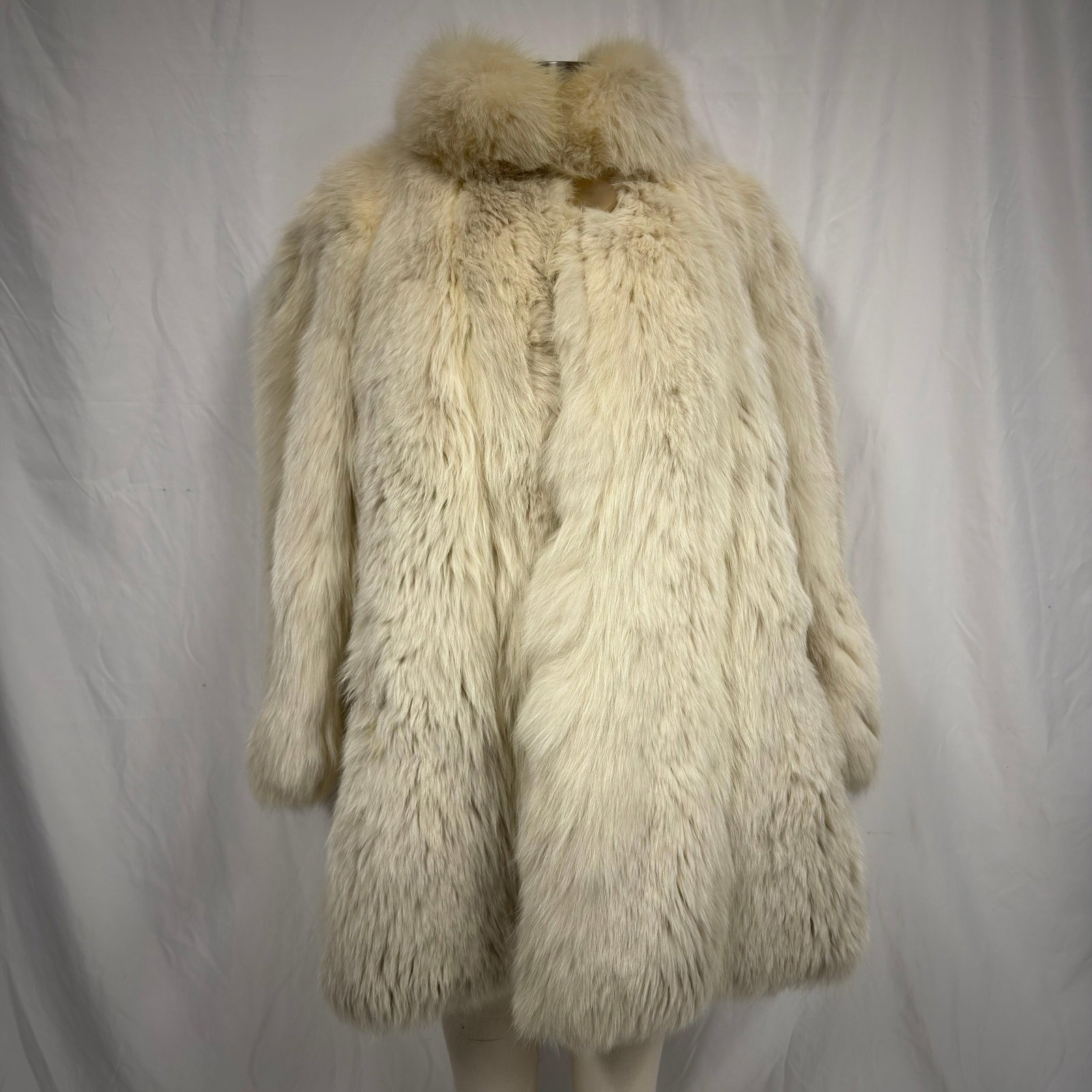 Ivory Tone White Fox Fur Coat Collard Design: The fur coat appears to be crafted from genuine fur (exact species unknown) and retains excellent volume and softness. Overall, the Fur Coat is in good pre-owned condition, with some light wear from s