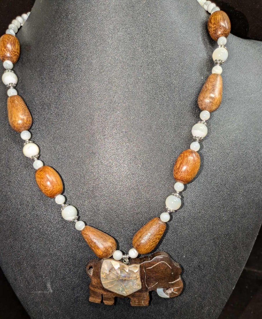 Vintage Lee Sands Elephant Pendant Necklace: Vintage Lee Sands Elephant Pendant Necklace. This lot has a wood elephant with abalone inlay and wood and mother-of-pearl beads. The beads feature oval and elongated teardrop wood beads and mothe