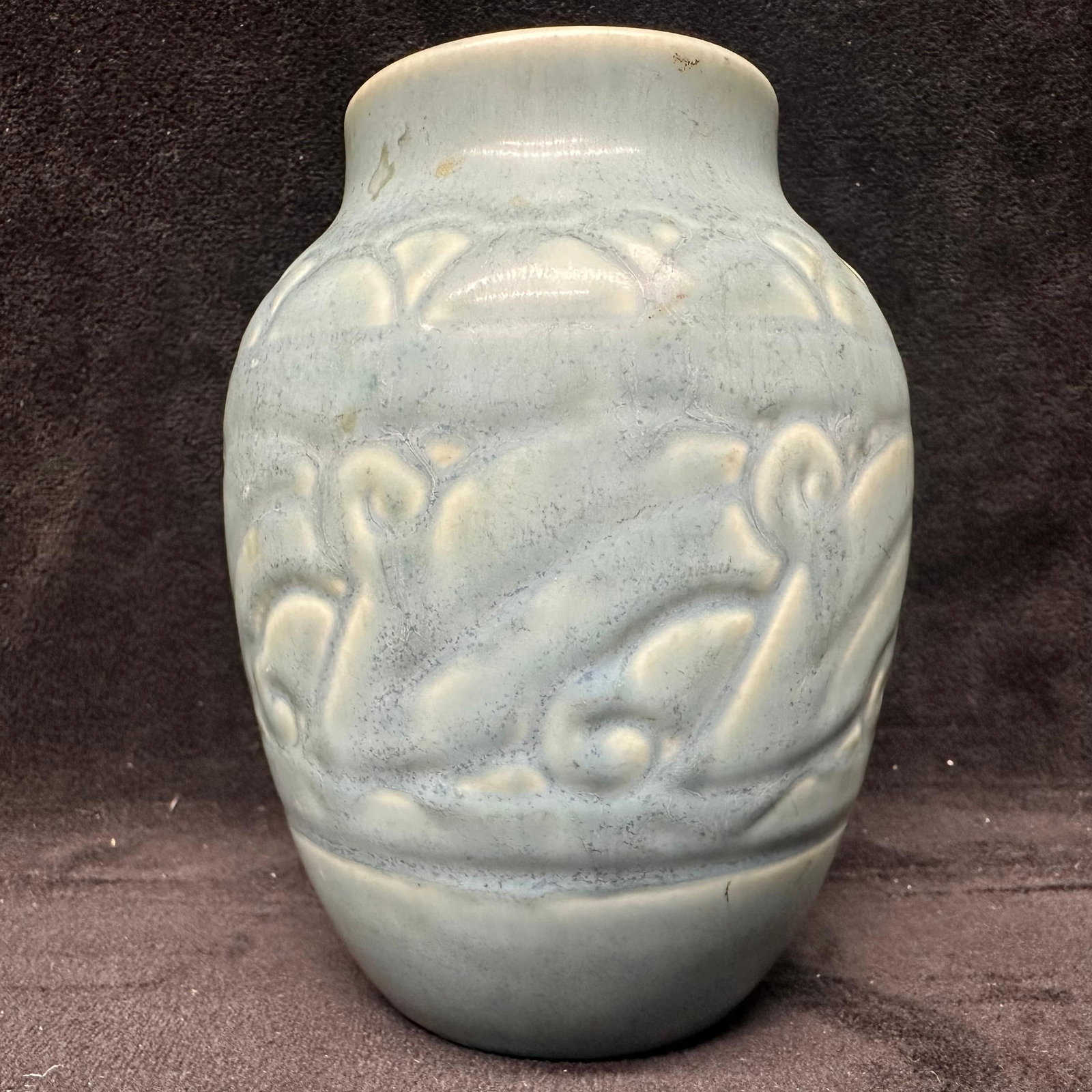 Rookwood Pottery Vase Art Deco Style Blue Glazed Ceramic Vase with Stylized Design Motif: Decorative ceramic vase featuring a soft blue-green glazed finish with raised stylized motifs in relief around the body. The vase has a rounded shoulder, straight neck, and a slightly tapered bas