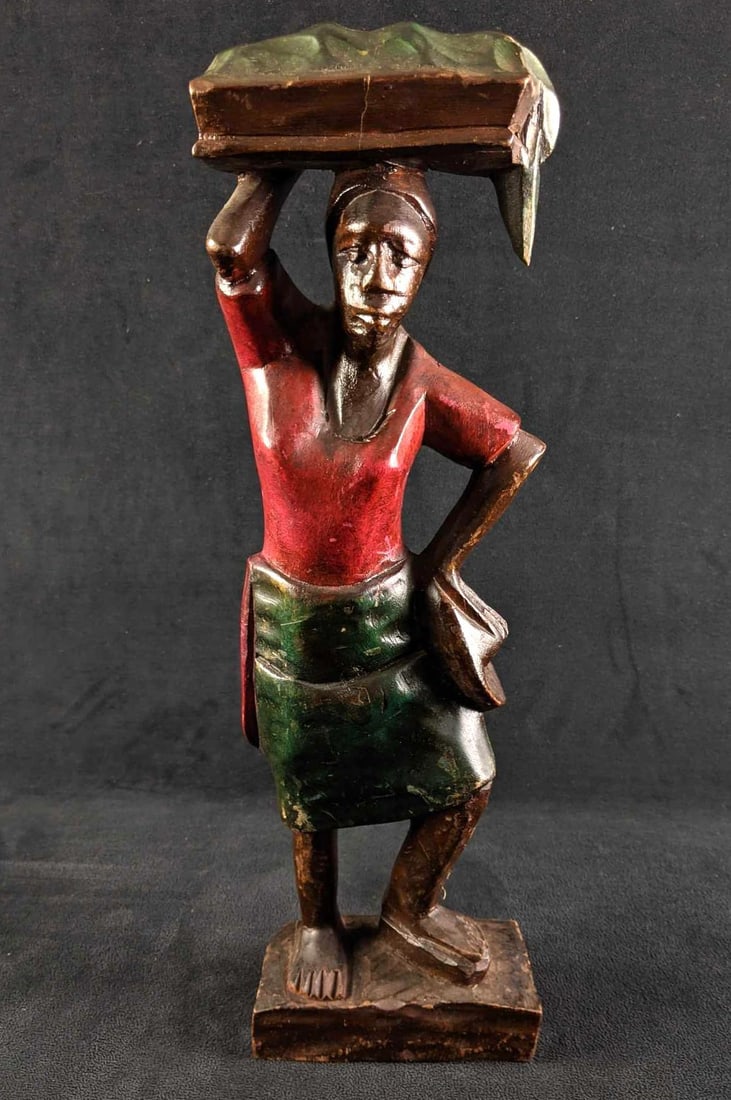 Wooden African Lady Sculpture: Wooden African Lady Sculpture This African lady sculpture is carrying a basket on her head. This sculpture is in good condition with some small scratches. This is made from wood with a glossy finish.&