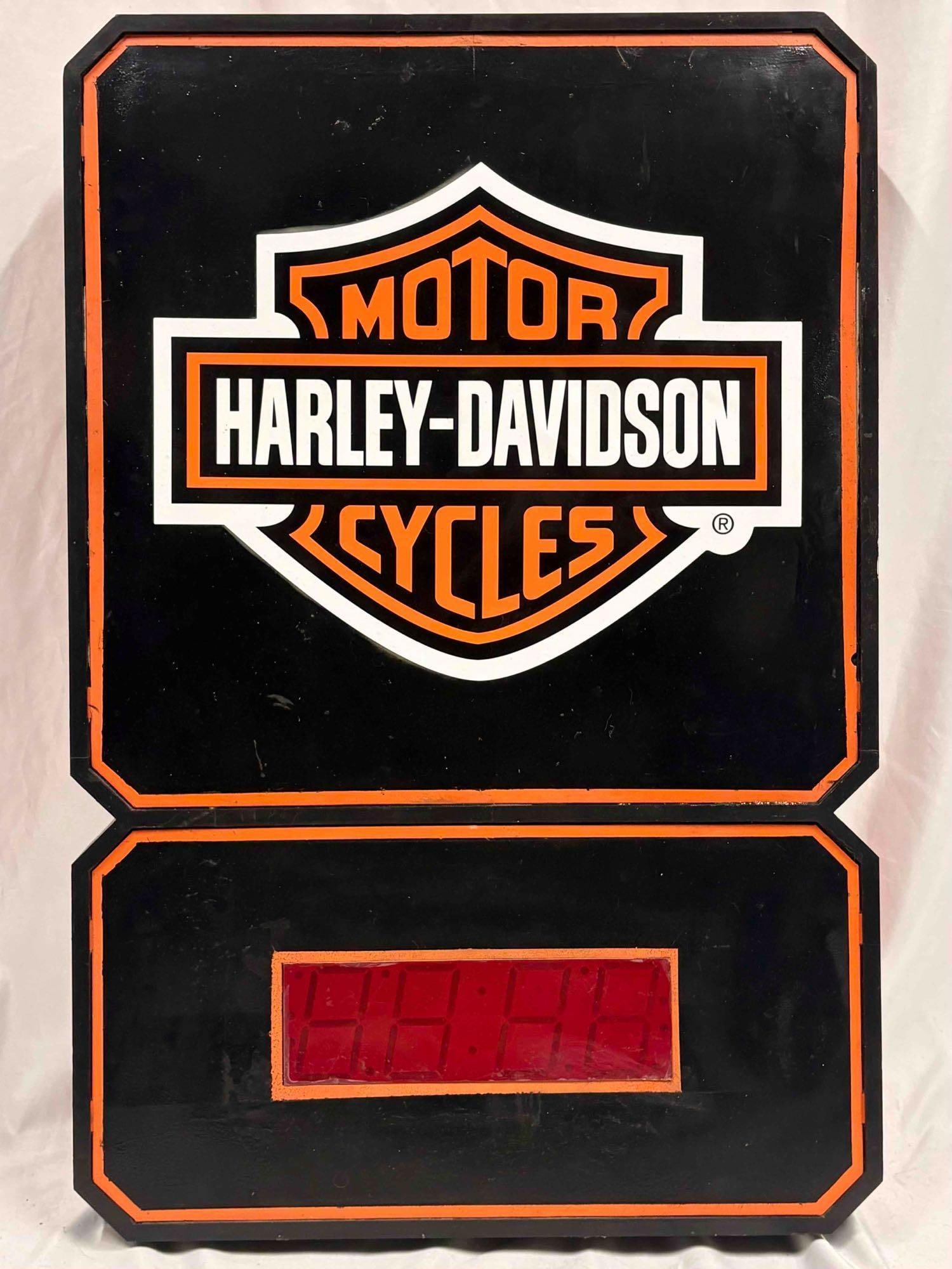 Harley Davidson Lighted Sign Featuring Digital Clock with Bar and Shield Logo: The design of this digital clock includes black housing with white and orange accents, displaying the Harley-Davidson logo. Designed as a decorative collectible for bars. The suface paint does