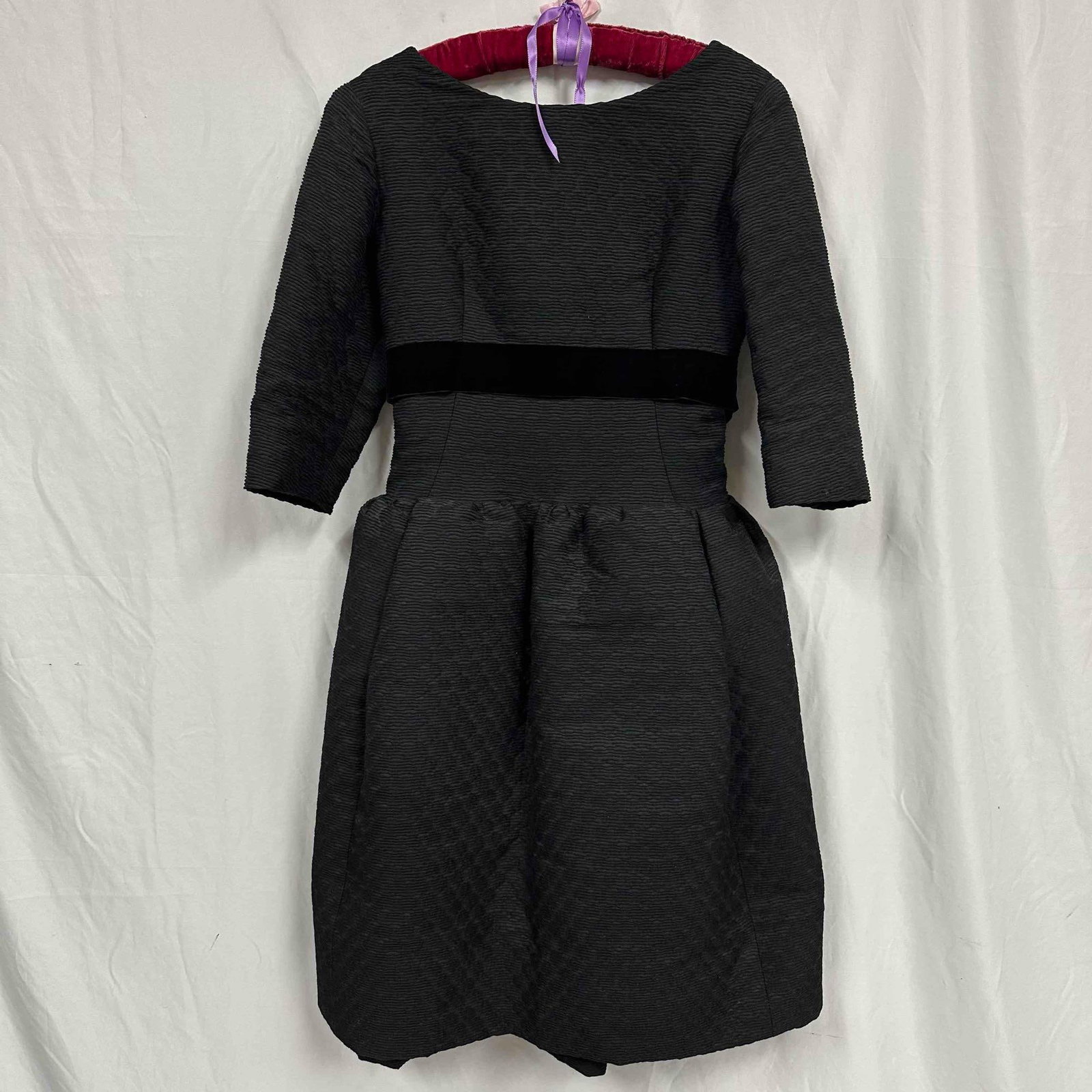 Classic Black Manuel Pertegaz Textured Ribbed Dress: This is a black dress with a textured, ribbed fabric. The dress is gathered and has a slightly puffed silhouette. Overall the dress is in good condition, with some light wear from storage and age.