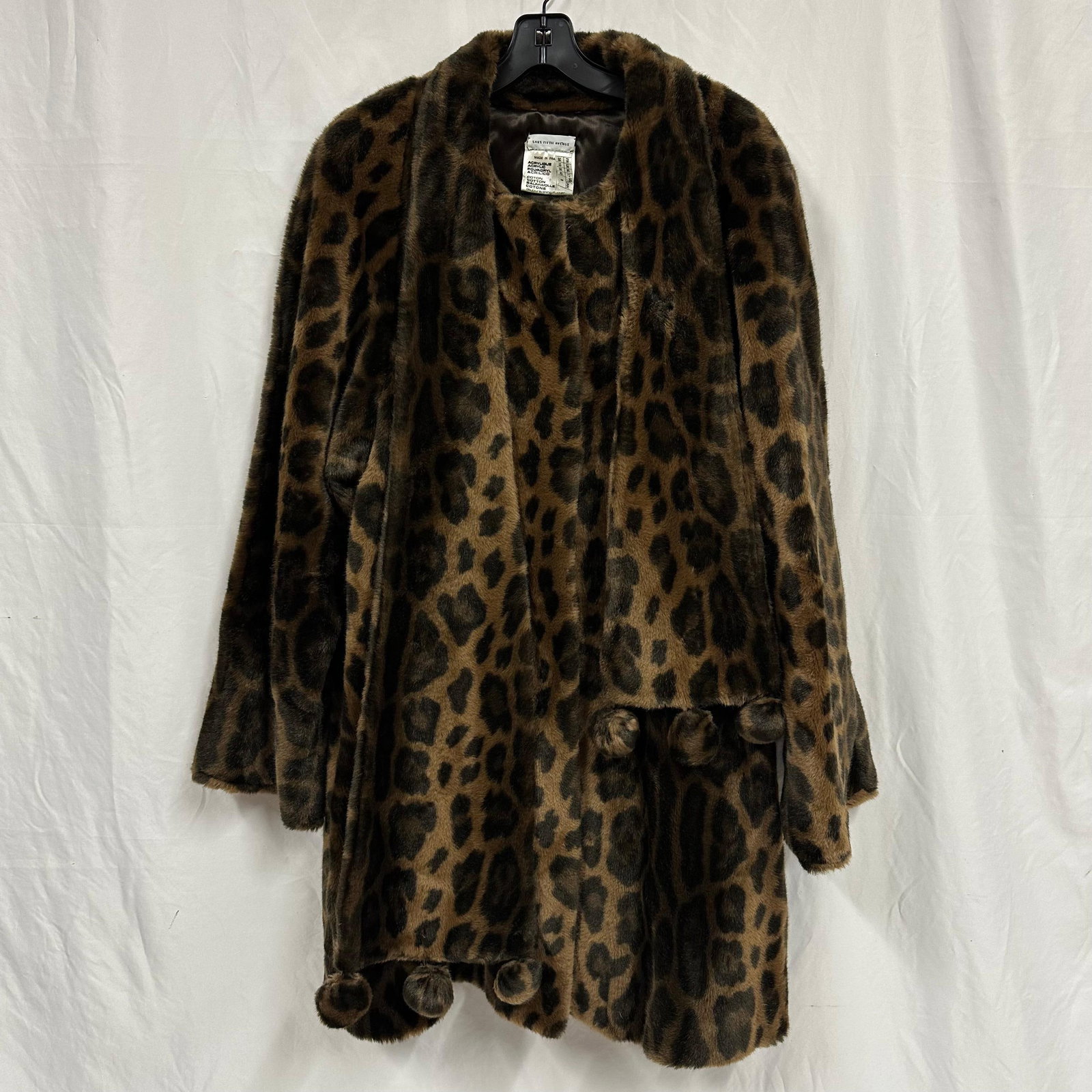 Saks Fifth Avenue Leopard Print Faux Fur Coat Scarf Style Pom-Pom Trim: Women’s leopard print faux fur coat by Saks Fifth Avenue. Made in France. Soft faux fur exterior with wide lapel collar and decorative pom-pom trim at the hem and front. Fully lined interior. No