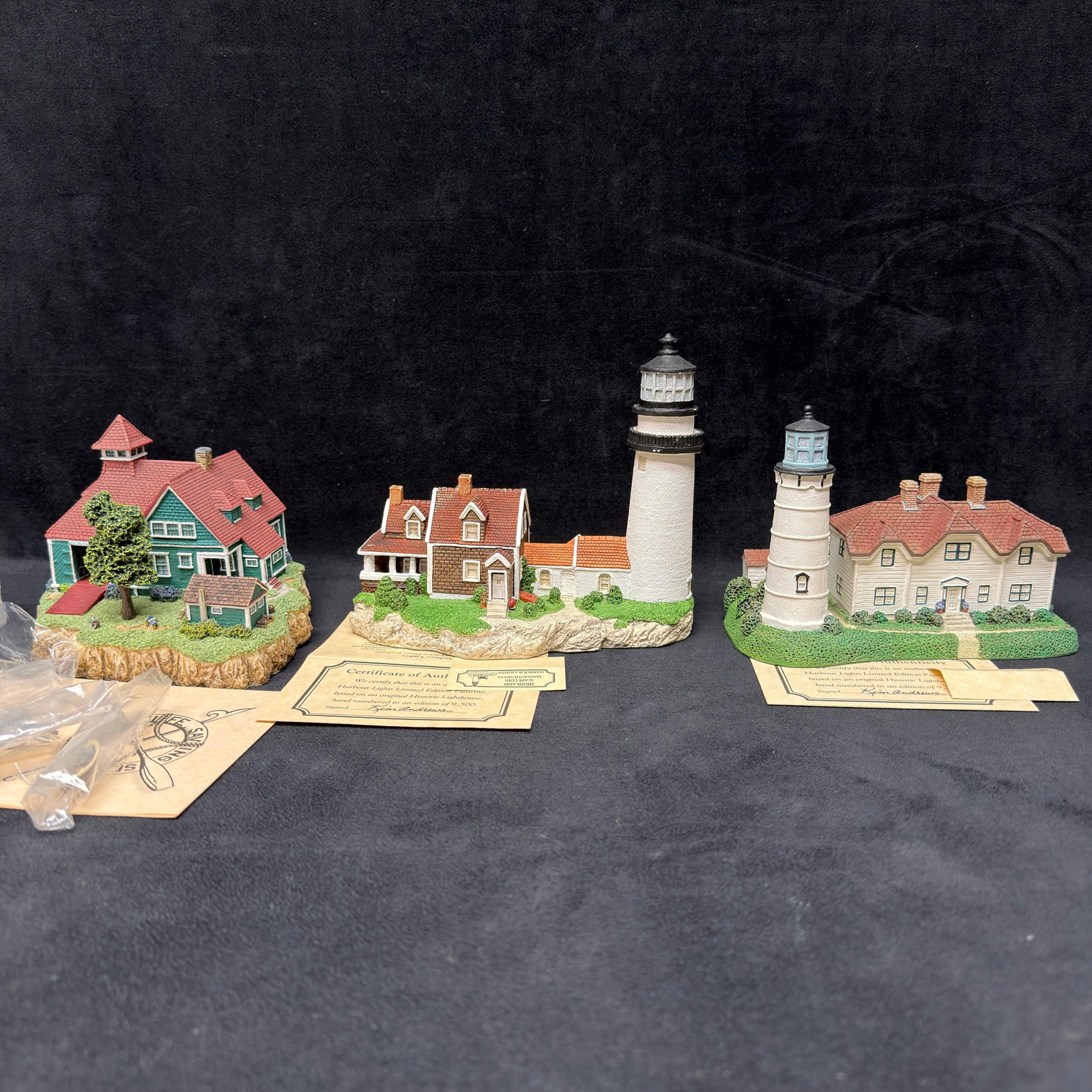 Three Harbour Lights Massachusetts Lighthouse Figurines USLSS Point Allerton: Lot of three Harbour Lights collectible lighthouse figurines by Younger and Associates, featuring Massachusetts landmarks. Includes USLSS Point Allerton #1635, Highland (Cape Cod) Light #161, and Lady