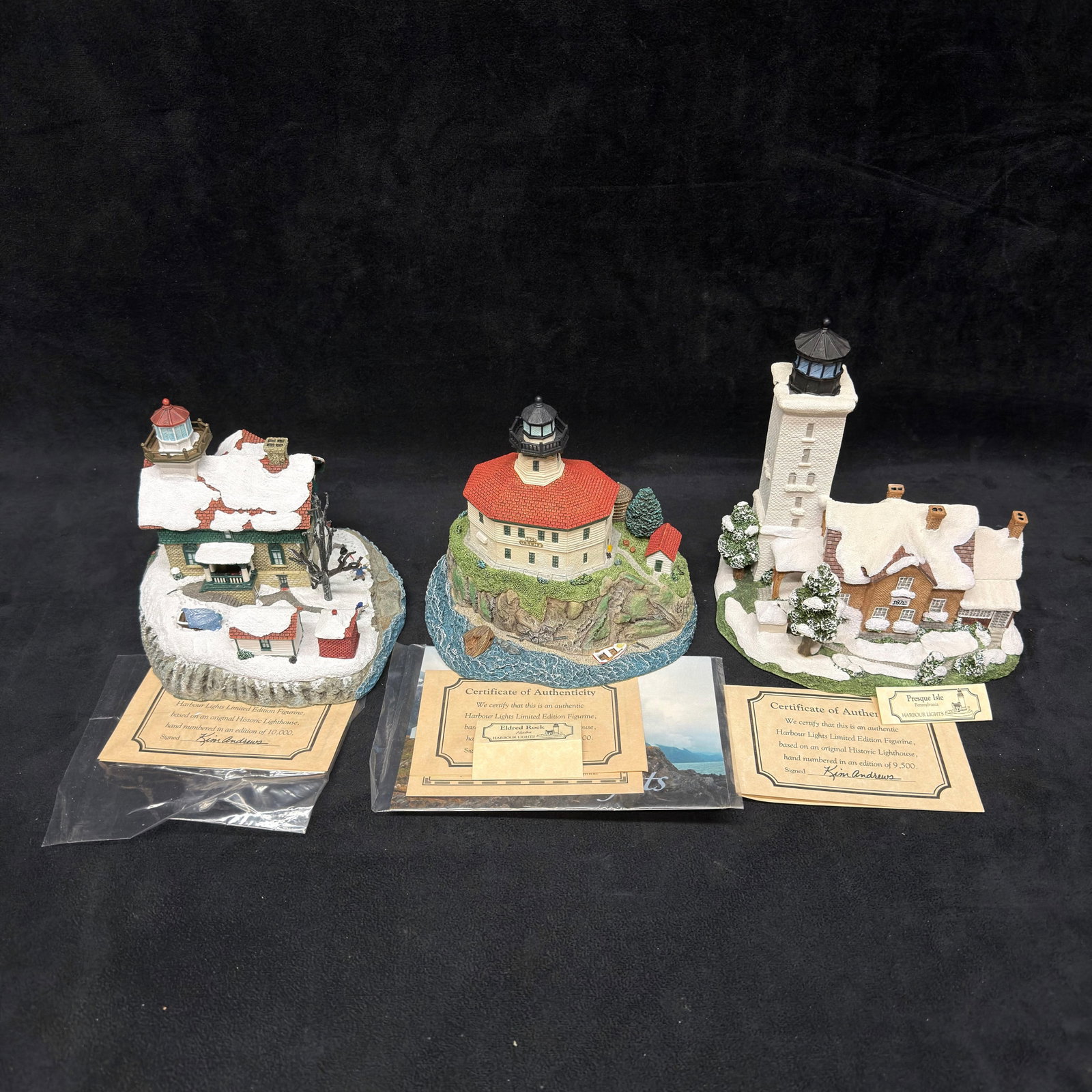 3 Harbour Lights Lighthouse Landmark Figurines Pennsylvania Alaska: Group of three Harbour Lights collectible lighthouse figurines, including Christmas 2001 Michigan City, Indiana #712; Eldred Rock, Alaska #257; and Presque Isle, Pennsylvania #201. Detailed hand-paint