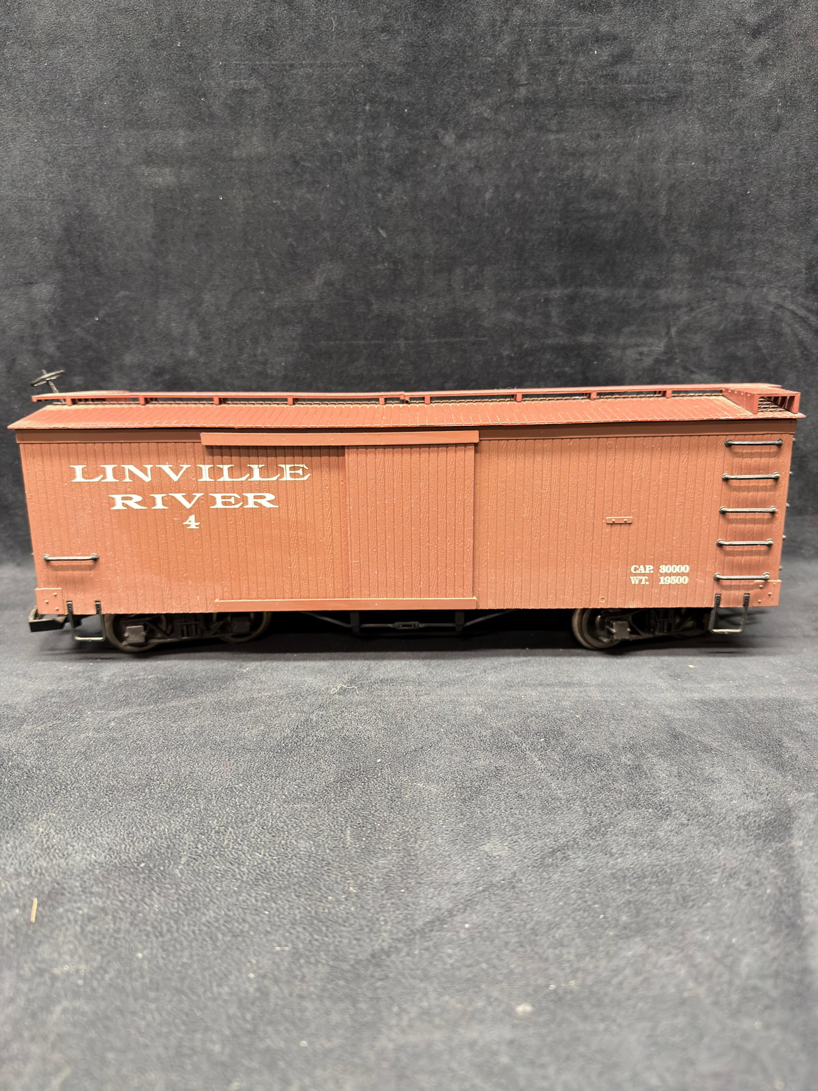Bachmann G Scale Linville River #4 Boxcar: Bachmann large-scale Linville River boxcar No. 4 in brown finish. Features sliding side doors, roof walkway, ladders, detailed undercarriage, metal wheels, and couplers. Marked Bachmann China on the u