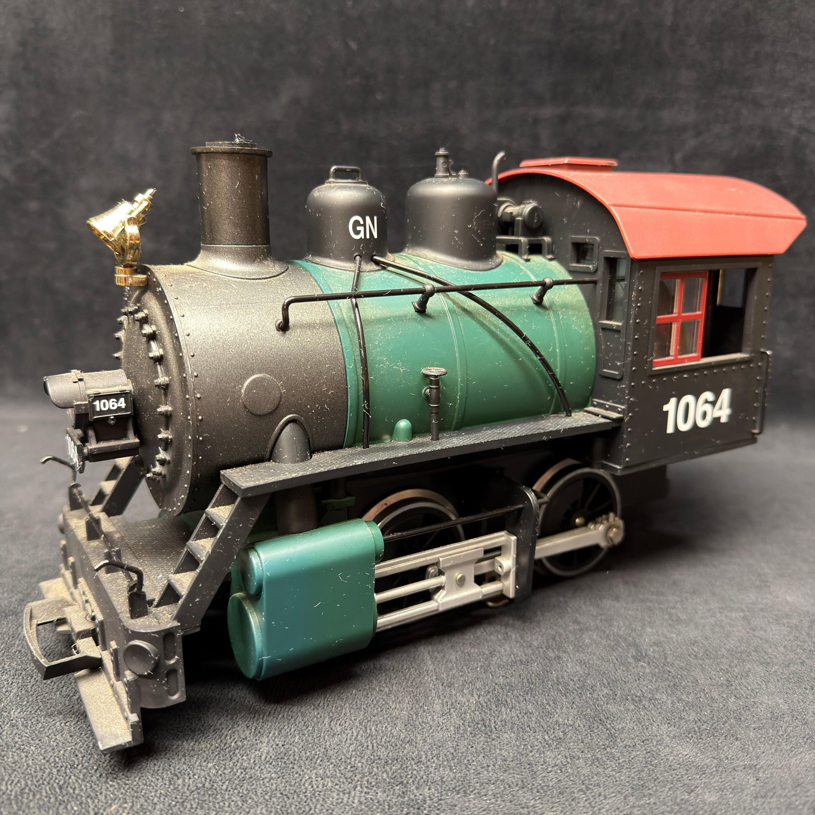 LGB 22232 Great Northern GN Road No. 1064 G Scale Steam Locomotive: LGB Great Northern Railway G scale steam locomotive No. 1064, model 22232. Features a green boiler, black cab, red roof, brass-tone bell, and detailed running gear. Electronics have not been tested an