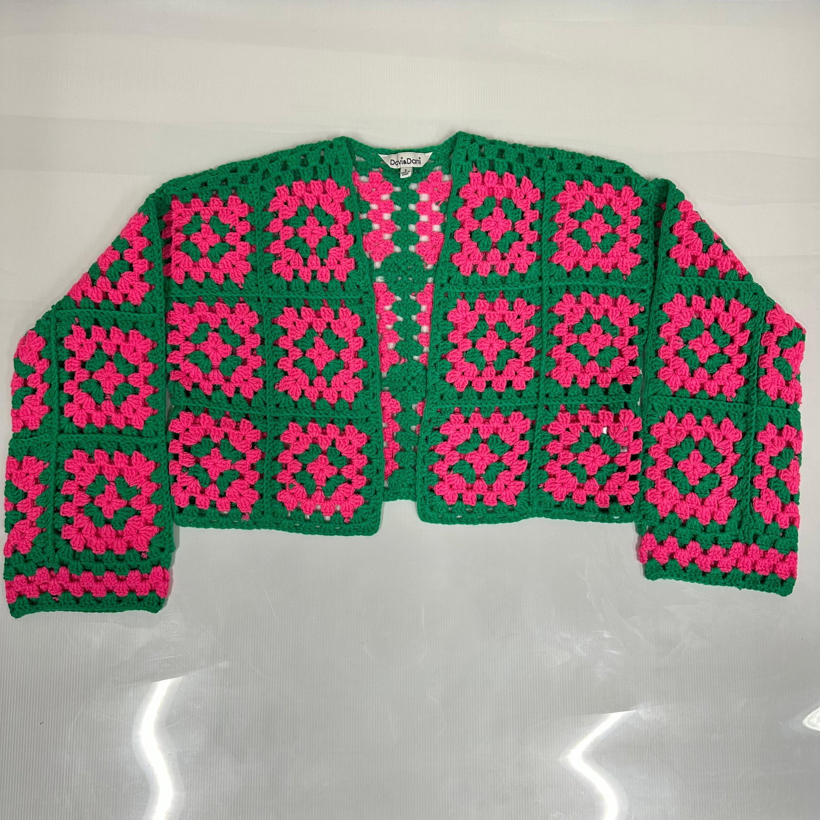 Davi and Dani Crochet Granny Square Cardigan Pink and Green Size Small: Bold and colorful crochet cardigan by Davi & Dani, featuring a classic granny square pattern in bright pink and green. Open-front style with long sleeves and a cropped fit. Tag reads Size Small. F
