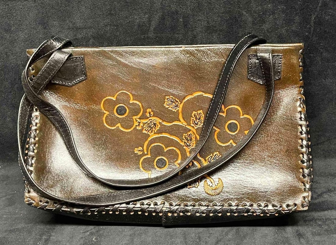 Vintage Leather Handicraft Purse With Embossed Flowers (19): This lot contains a Vintage Leather Handicraft Purse With Embossed Flowers (19). The bag is hand-stitched and has a very soft leather liner and inside zipper pocket. It is approx 12" x 2 3/4" x 7