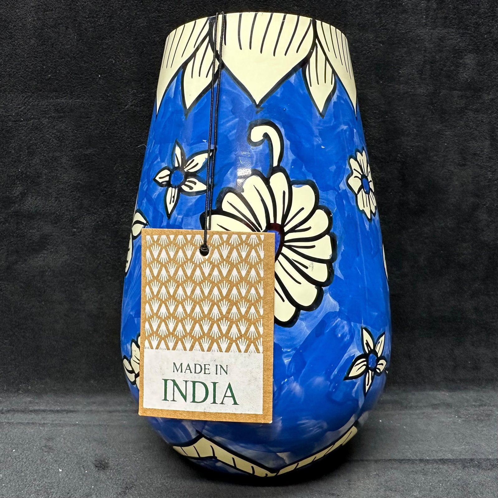 Hand-Painted Blue Floral White Flower Ceramic Vase Made in India: Handcrafted ceramic vase featuring a hand-painted blue ground with cream white floral decoration and black outlining. Labeled as handcrafted and hand-painted by artisans in India. Each piece is