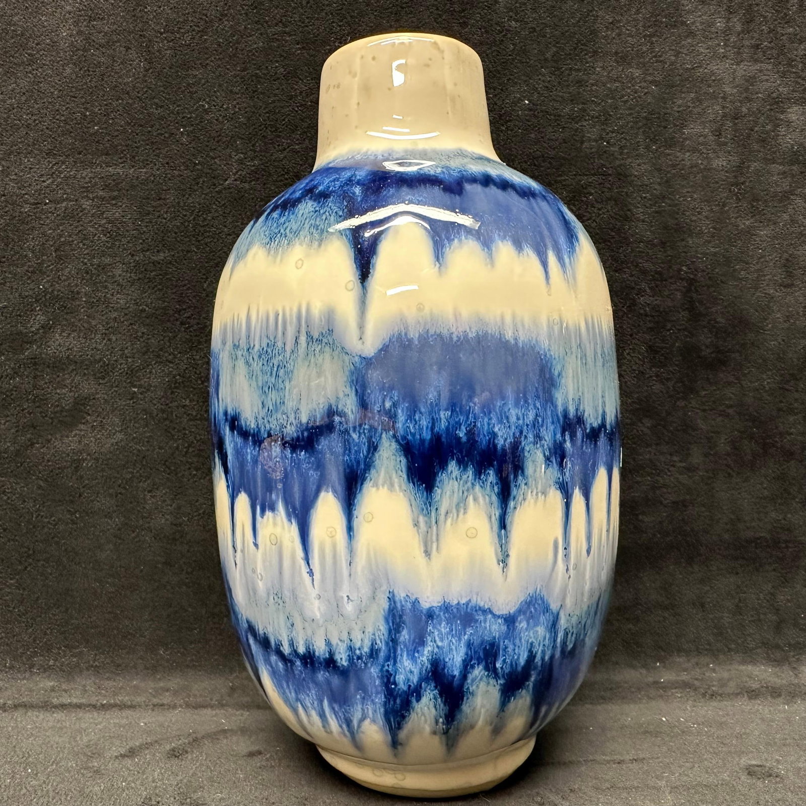 Blue and Cream Drip-Glaze Style Ceramic Vase Made in Thailand: Decorative ceramic vase featuring a rounded body with a short neck and blue-and-cream drip glaze decoration. Glossy glazed exterior with unglazed foot. Marked Made in Thailand on the underside. No