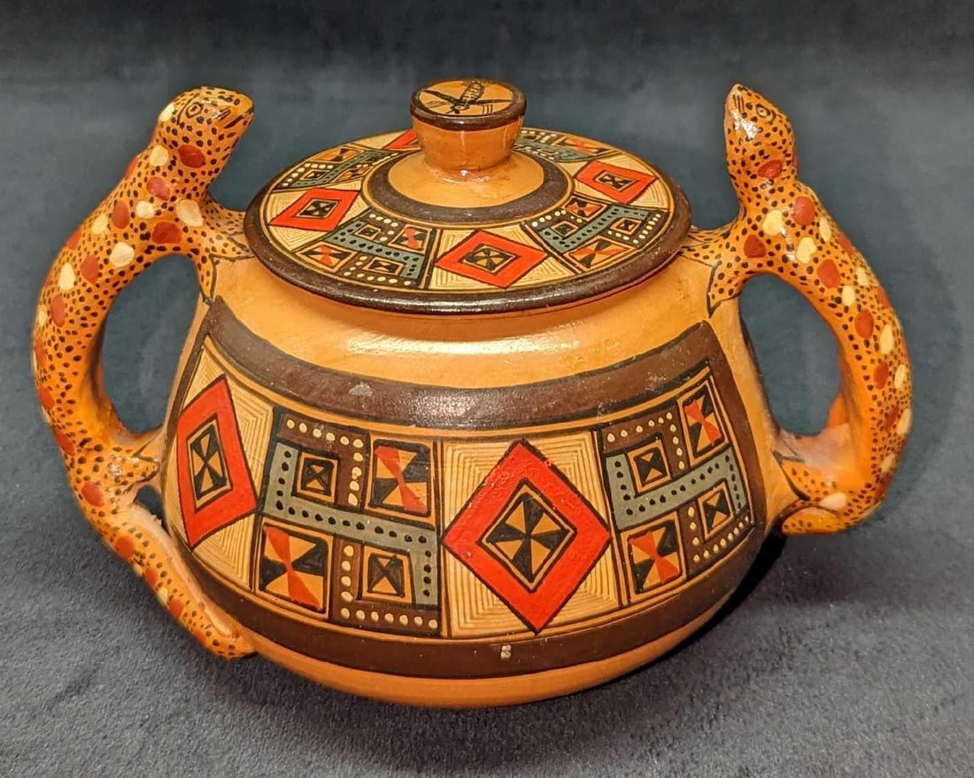 Hand Painted Peruvian Style Ceramic Pot With Lid: Hand Painted Peruvian Style Ceramic Pot With Lid. With Gecko/Lizard handles. Is approx 7" x 5" x 4" and it weighs 0.86lb. Its maker and date of creation is unknown. One of the handles is missing part 