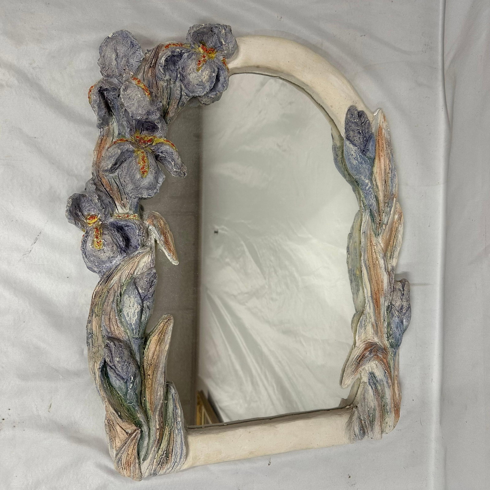 Decorative Floral Relief Wall Mirror with a Sculpted Purple Flower Frame: Decorative wall mirror featuring a sculpted frame with raised floral and leaf motifs in soft blue, lavender, green, and cream tones. Appears to be made of molded plaster, resin, or composite material 