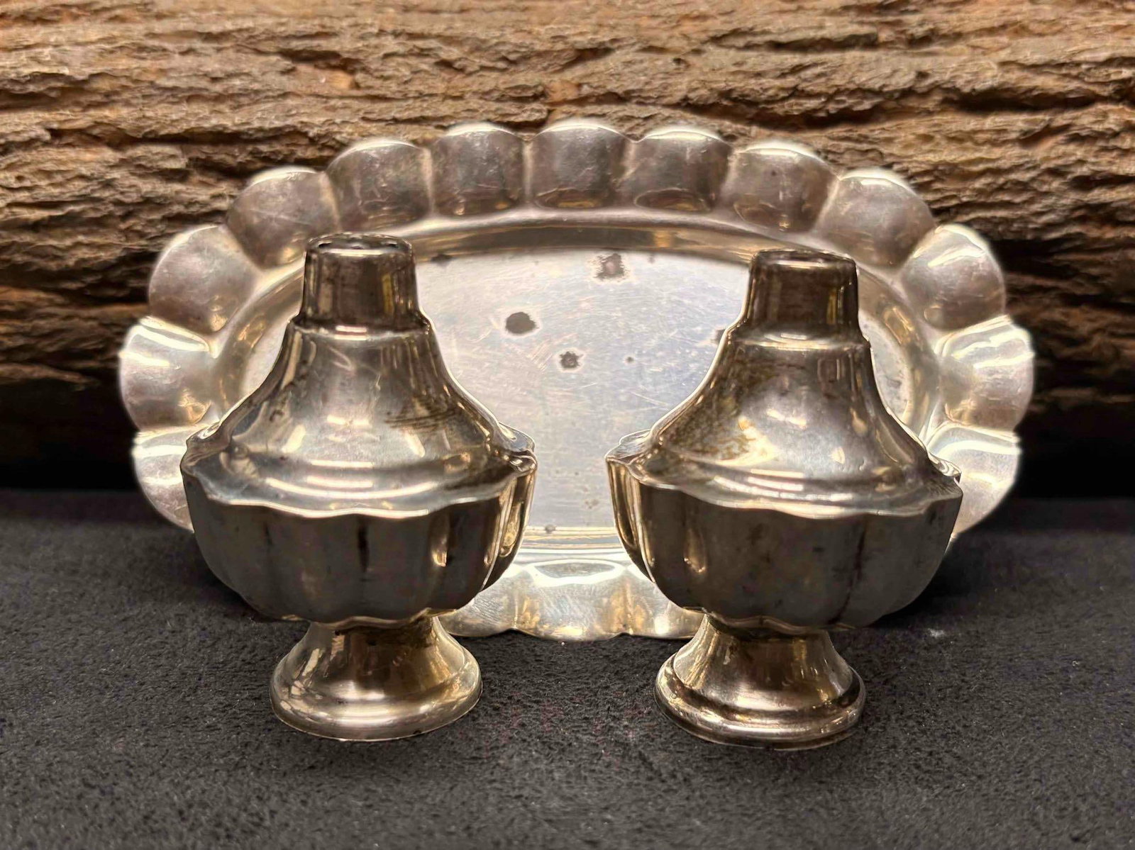 3pc 1970s Mexican 925 Sterling Silver Salt Shakers and Trays: This lot containers a salt and pepper shaker, displaying ornate Mexican motifs and ribbed bodies. The base of the shakers unscrew, allowing it to be refilled. Due to age, the grooves and nooks of the 