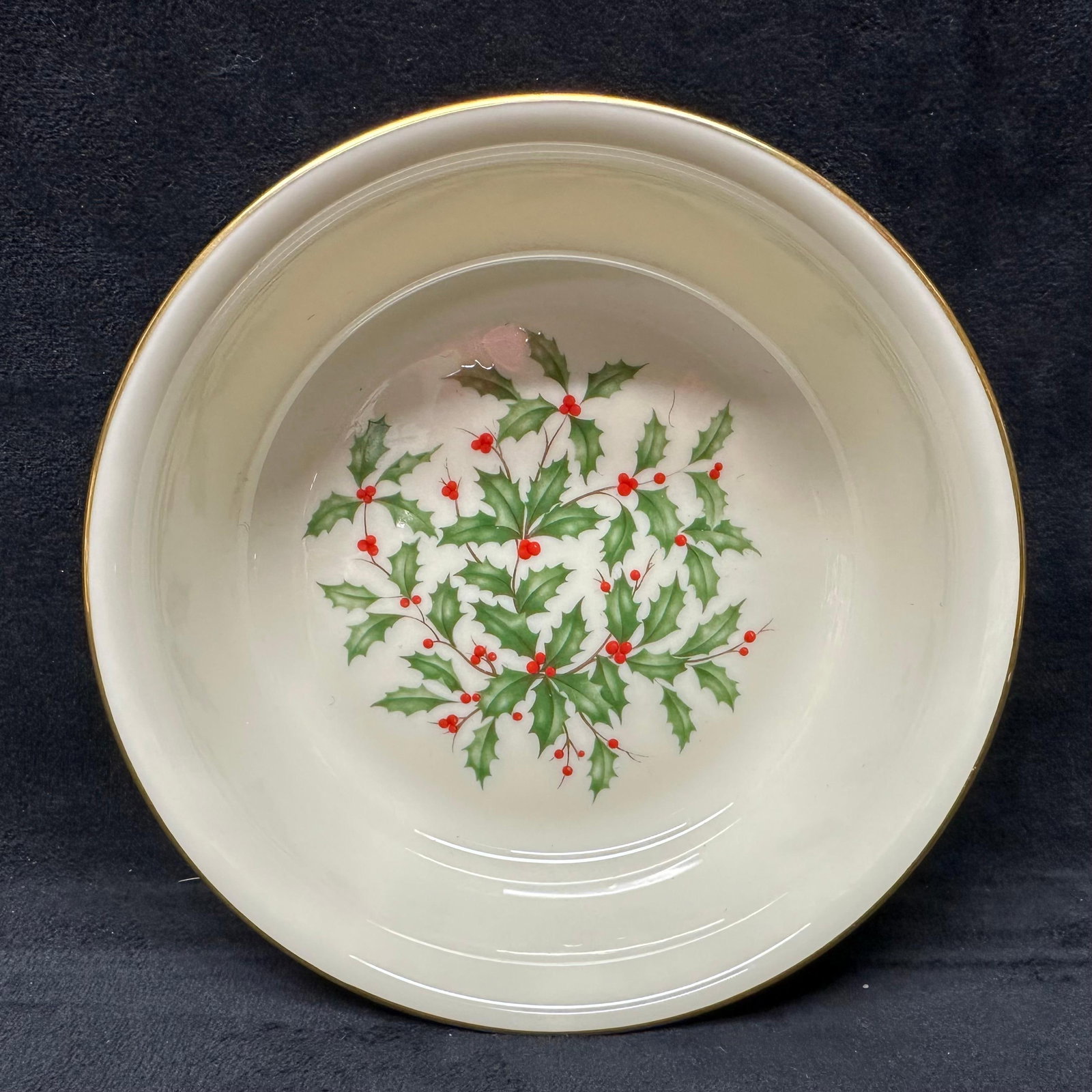 Lenox Holly Pattern Porcelain Serving Bowl with Gold Rim: Round porcelain serving bowl by Lenox, featuring the classic holly leaf and red berry motif at the center with a gilt rim. Marked on underside Lenox Made in U.S.A. Special. Smooth cream glaze througho