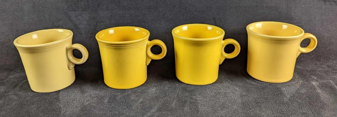 4 Yellow Sunflower HLC Fiesta Mugs: 4 Yellow Sunflower HLC Fiesta Mugs. Each is approx 5" x 2 1/2" x 3 1/2" and together they weigh 3.66lbs. The mugs are in good, used condition with some signs of wear and scratches inside the mugs and 
