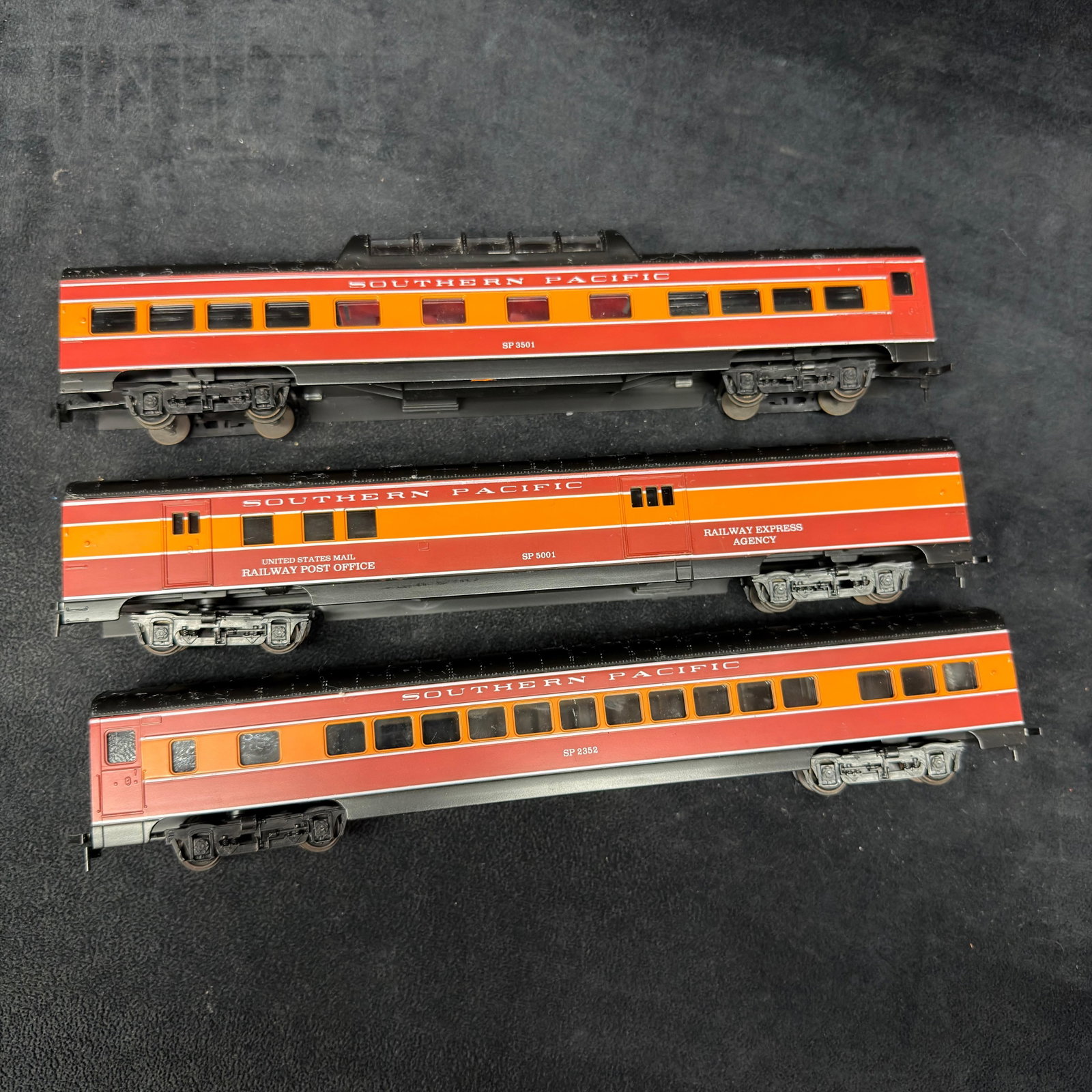 Southern Pacific HO Scale Passenger Cars 3 Model Train Railway Post Office Car: Group of three Southern Pacific HO-scale passenger cars in red, orange, and black Daylight-style colors. Includes cars marked SP 2352, SP 23501, and SP 5001 “US Mail Railway Post Office.” 