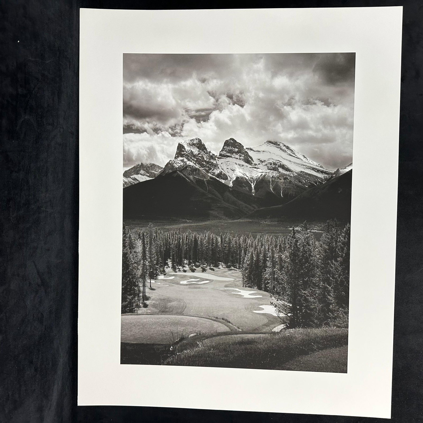 Three Sisters Mountain Canmore Alberta Canadian Rockies Black and White Inkjet Photo Print: Black-and-white inkjet photo print featuring the iconic Three Sisters mountain peaks in Canmore, Alberta, part of the Canadian Rockies. The composition beautifully captures a golf course in the foregr