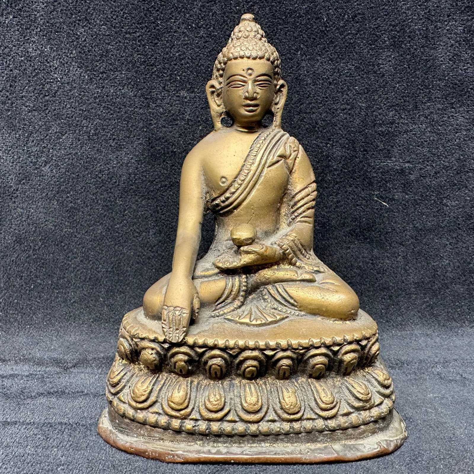 Tibetan Himalayan Style Brass Seated Buddha Sculpture with Vajra Mark: Cast brass Buddhist figure depicting Shakyamuni Buddha seated in the earth-touching Bhumisparsha mudra, holding an alms bowl and resting on a double lotus base. The underside bears a Vajra