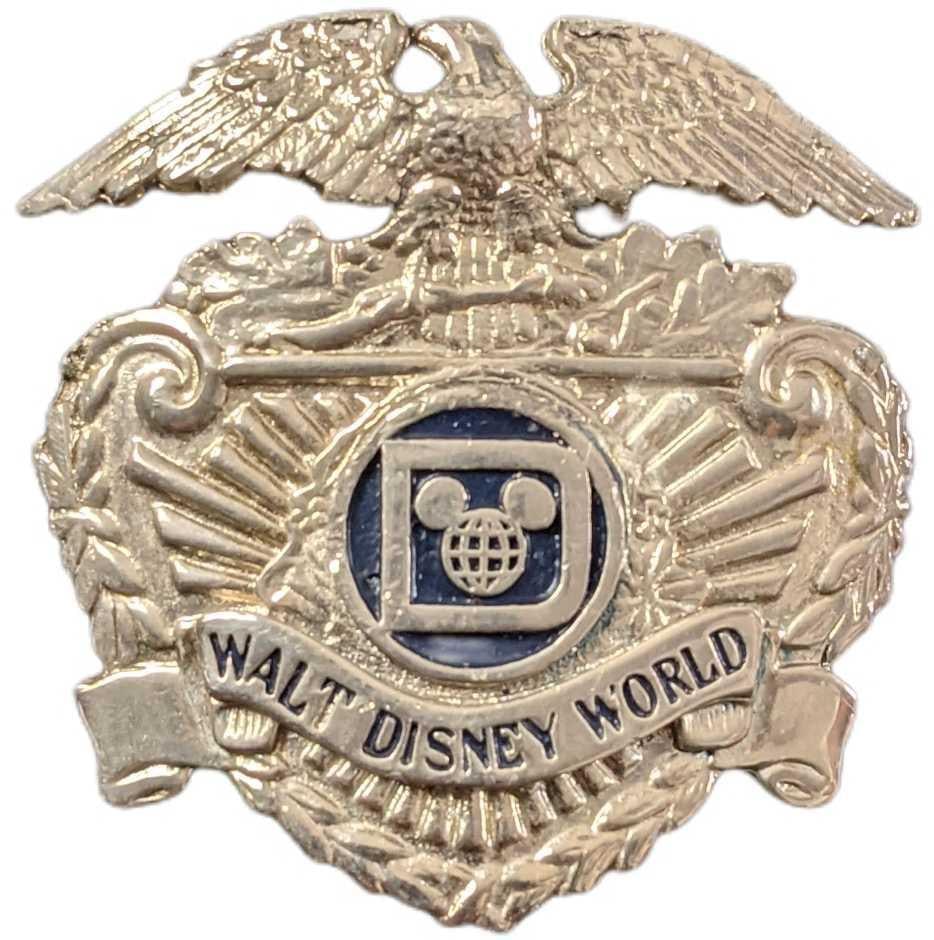 1970s/1980s Walt Disney World Security Hat Badge: This badge adorned the hat of the Walt Disney World Park Security Employees during the 1970's/1980s. The back of the badge has two threaded prongs that fit through two holes in the hat and were