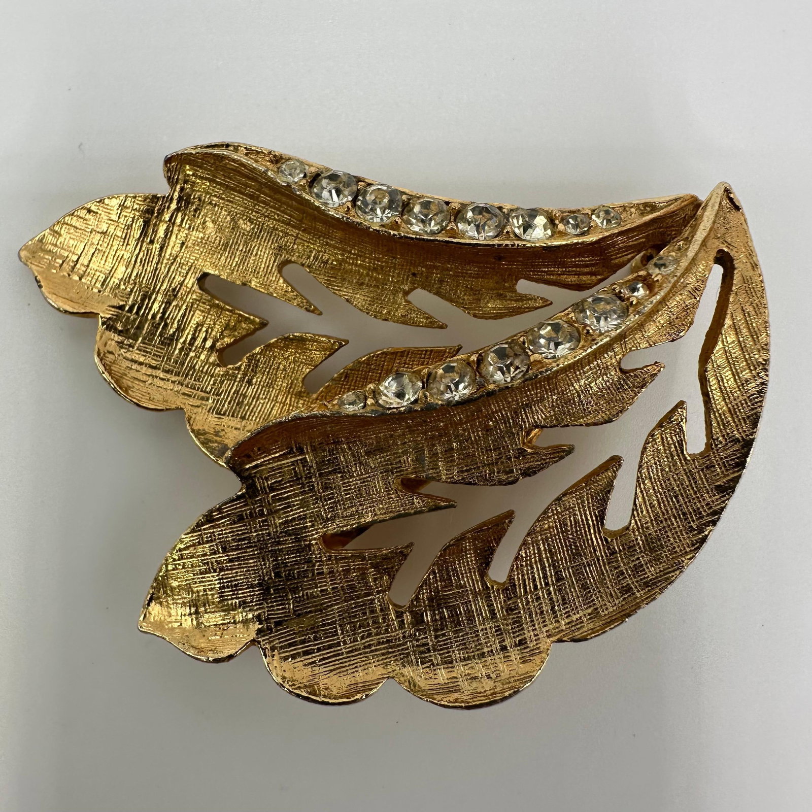 Double Leaf Rhinestone Brooch Bridal Fall Autumn Goldtone Vintage Style: Vintage gold-tone double-leaf rhinestone settings brooch/clip. No hallmarks. This item is in pre-owned, previously displayed condition with light wear and surface scratches. Please reference all photo