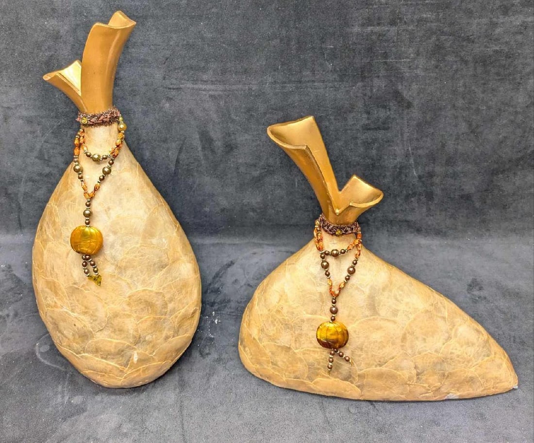2 Resin Shell Layered Mantel Vases B: 2 Resin Shell Layered Mantel Vases A. This appears to be two resin or plaster vases covered with a shell material. These are suitable for faux flowers. The tall vase is approx 8" x 4" x 16" and it