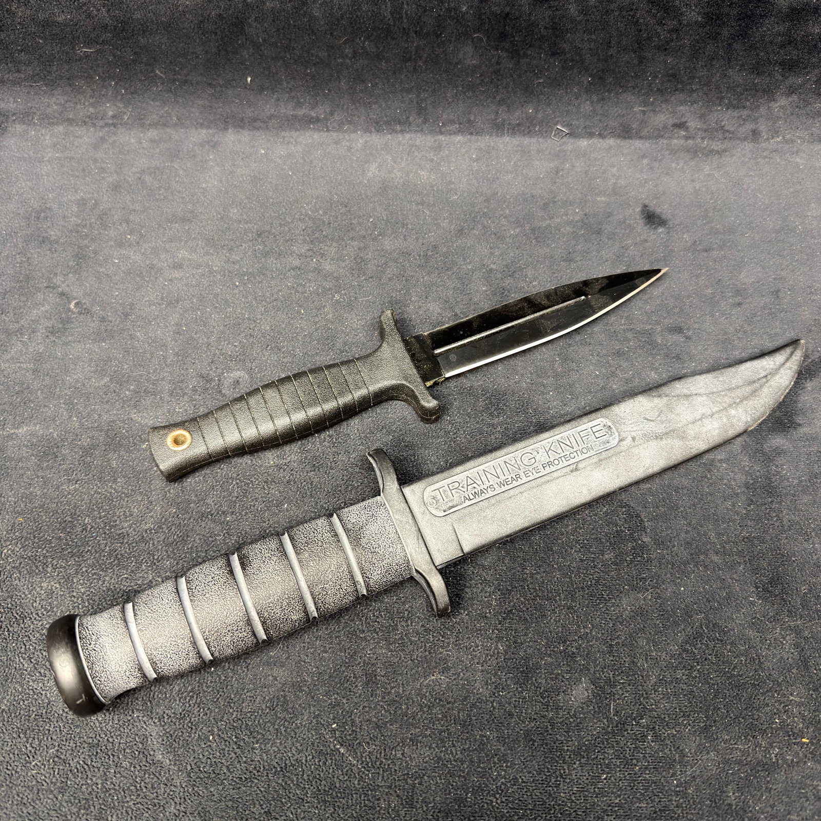 Tactical Training Knives Pair Knife Blade Set: One knife is plastic, and the other is metal with a plastic handle. These items are in pre-owned, vintage, previously displayed condition with wear, rust, small imperfections, discoloration, and surfa