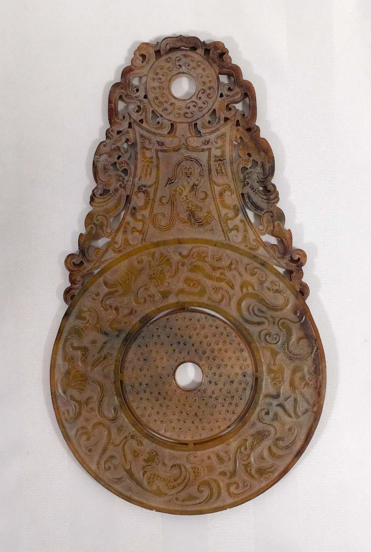Hanging carved stone disc: Hanging carved stone disc Description: Hanging carved stone disc Hanging carved stone disc. The circular frieze shows figures fighting felines and snakes and is surmounted by a female figure surrounde