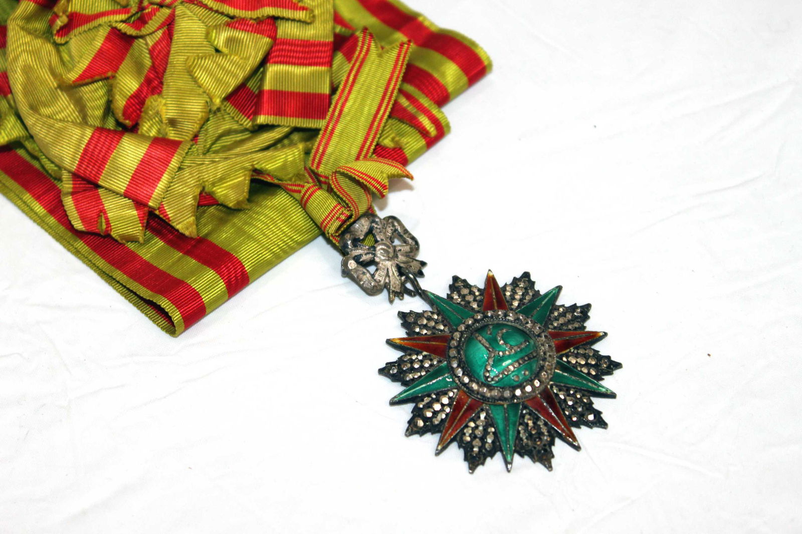 Tunisia 1880-1902 Commander of the Order of Ali Bey w/ Sash Used: Tunisia 1880-1902 Commander of the Order of Ali Bey w/ Sash Used Medal 45.3 gms. comes w/64 inch sash and rosette. Maker's mark in on the reverse of the badge in Arabic. The stars are all French steel